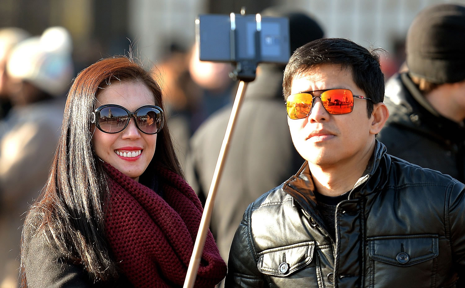 Tourists use a 'selfie stick' in London.