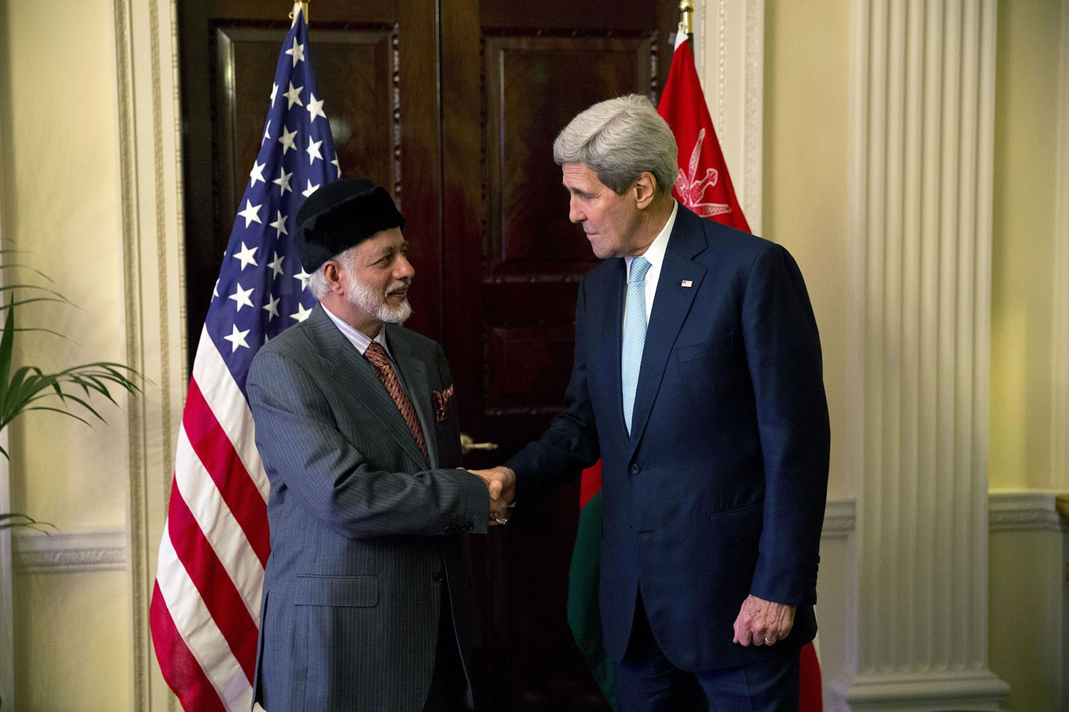 U.S. Secretary of State John Kerry, right, and Oman Foreign Minister Yusuf Bin Alawi bin Abdullah perform a posed handshake for photographers at the start of their meeting at the official residence of the U.S.