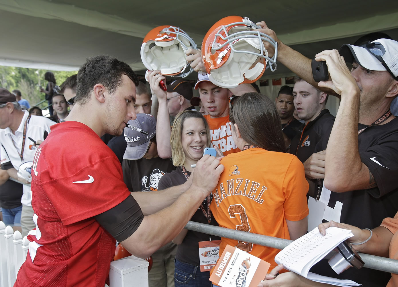 Cleveland Browns quarterback Johnny Manziel signs autographs for fans after his first practice at the NFL football team's training camp in Berea, Ohio on Saturday, July 26, 2014.