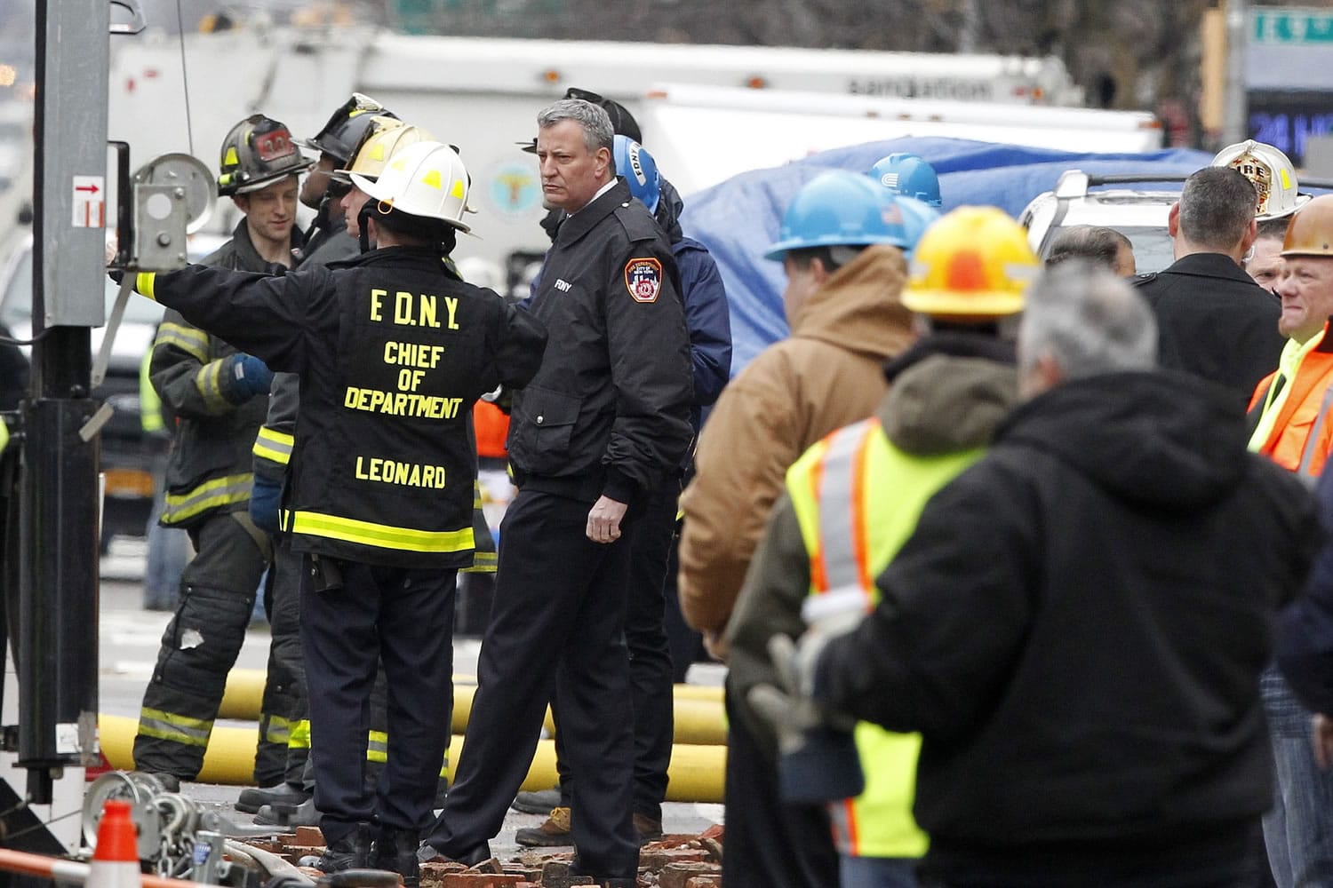 New York City Mayor Bill de Blasio, center, talks to FDNY Chief James Leonard, left, while visiting the site of a partial building collapse in the East Village neighborhood of New York on Friday.