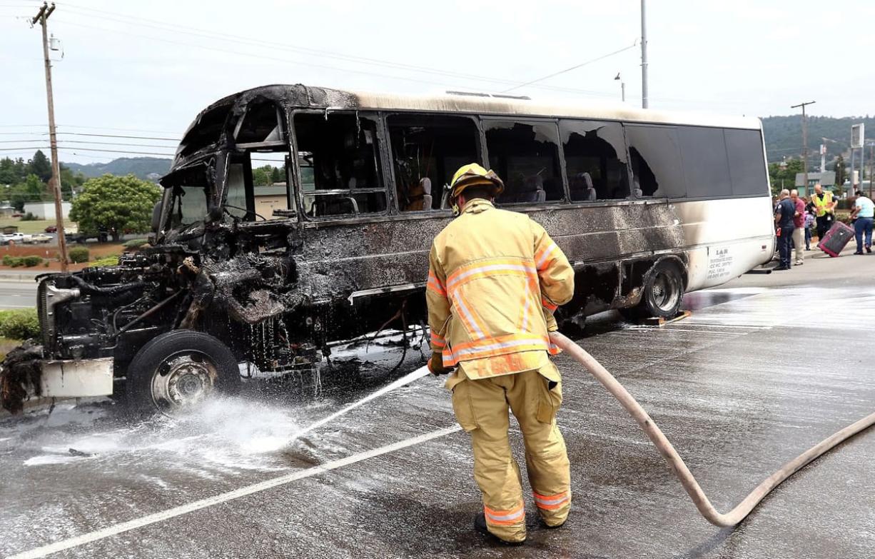 Roseburg Fire Department firefighter Parker Brown responds after a bus caught fire Tuesday in Roseburg, Ore.