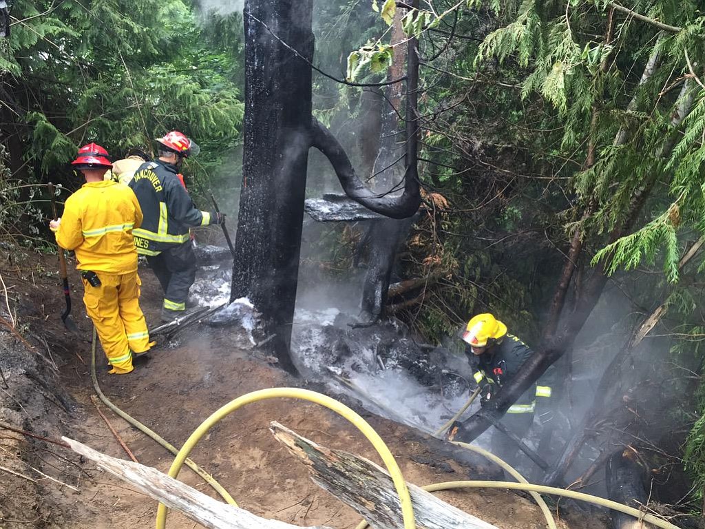 District 6 and Vancouver firefighters work to mop up a brush fire at a homeless camp in Hazel Dell.