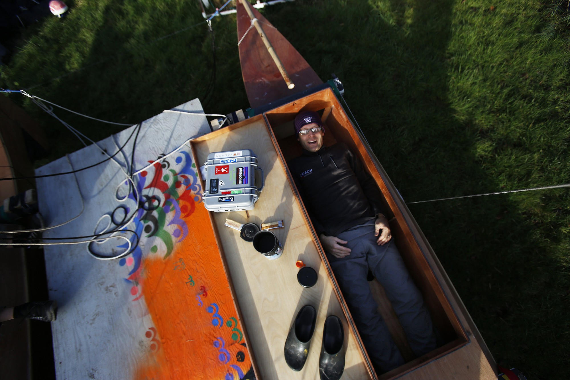 Scott Veirs tests what will be his sleeping space in one of the hulls of a 17-foot catamaran in Seattle.