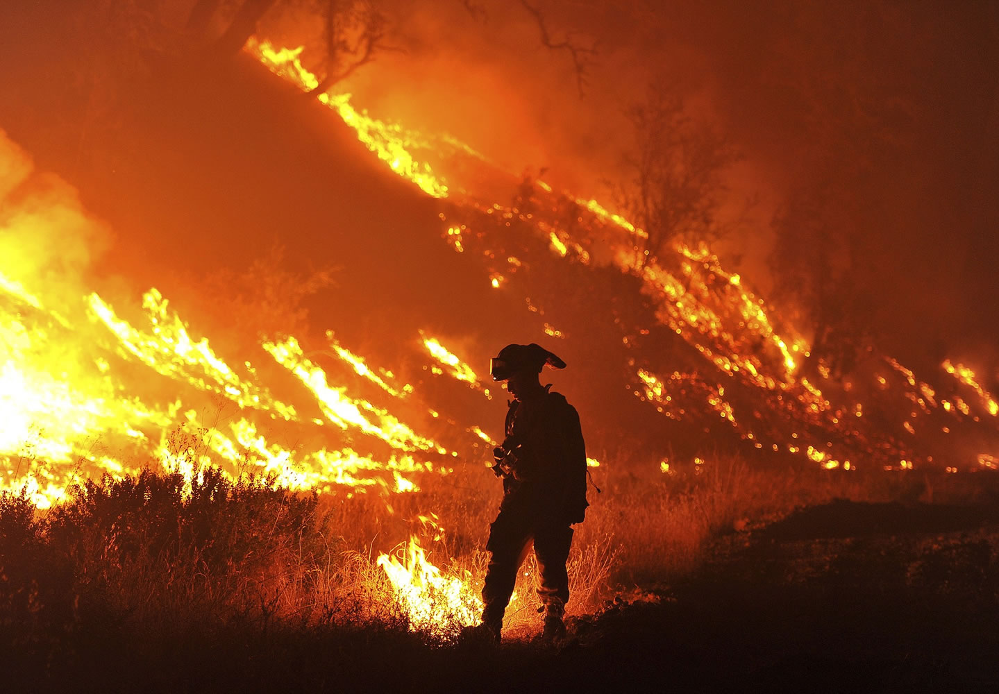 CalFire firefighter Bo Santiago lights a backfire as the Rocky fire burns near Clearlake, Calif.