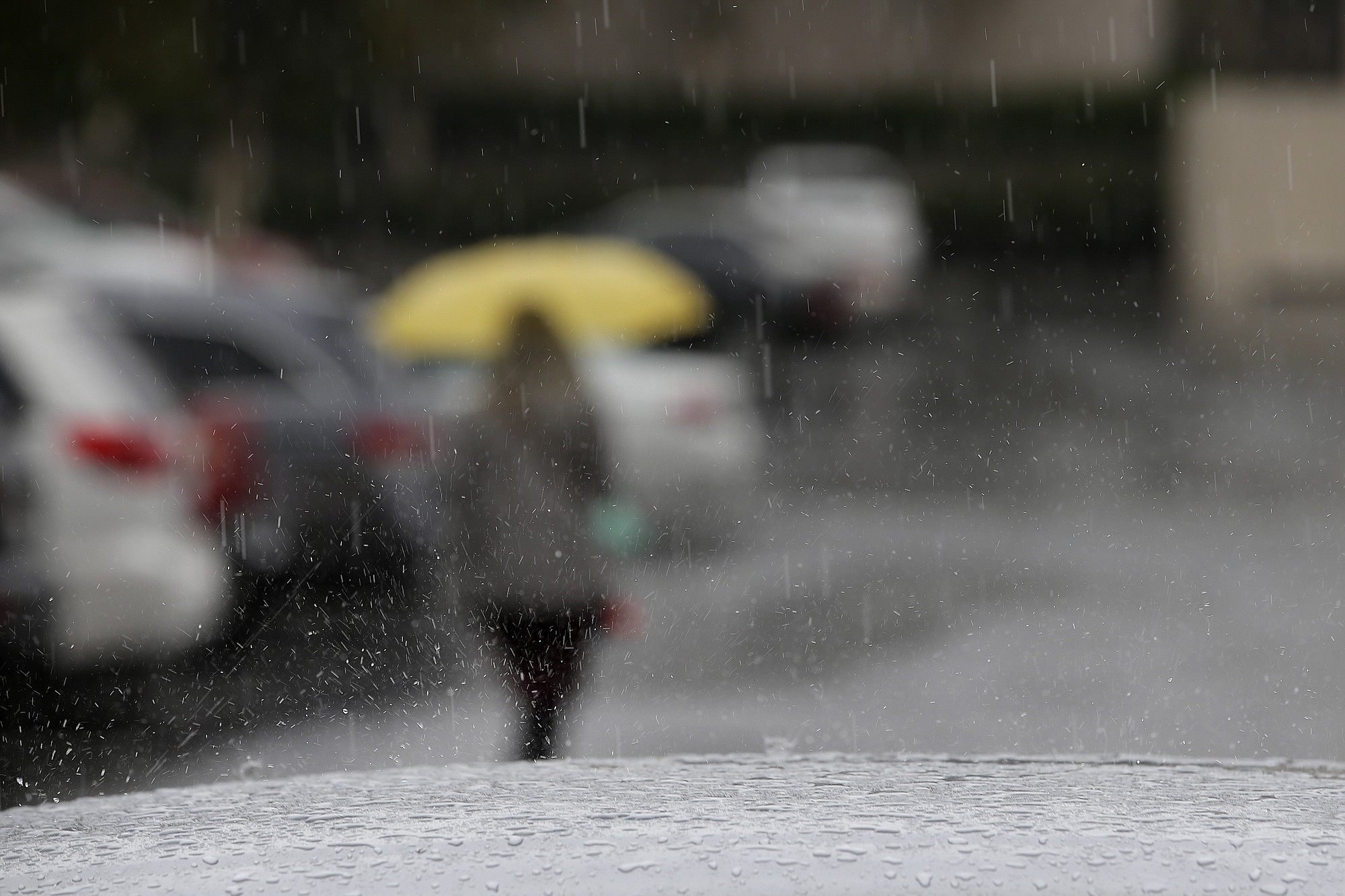 Rain drops fall Friday on a car parked outside a building in Buena Park, Calif. A second round of rain from a rare spring storm swept into drought-stricken Southern California on Friday, along with heavy winds, snow in the mountains and the possibility of hail and lightning. (AP Photo/Jae C.