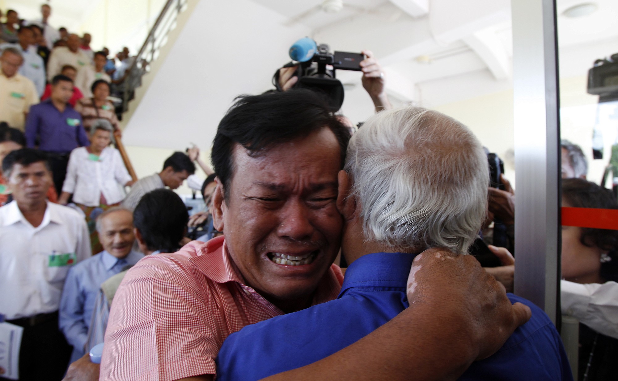 Cambodian former Khmer Rouge survivors, Soum Rithy, left, and Chum Mey, right, embrace each other after the verdicts were announced, at the U.N.-backed war crimes tribunal in Phnom Penh, Cambodia, on Thursday.