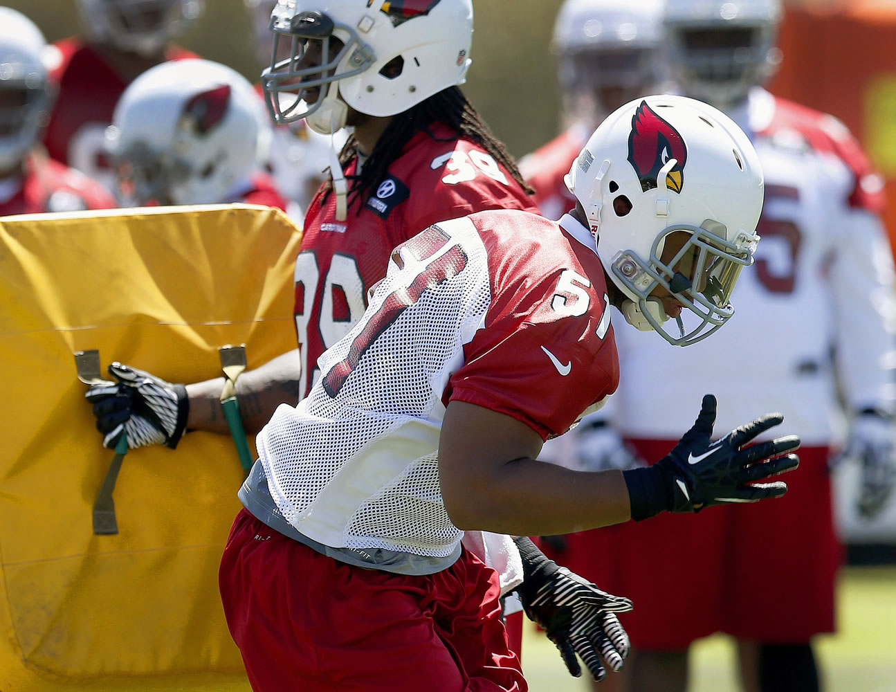 Arizona Cardinals' Kevin Minter (51) works on blocking and rushing drills with teammate Andre Ellington. Minter takes Karlos Dansby's place as the defensive signal caller. (AP Photo/Ross D.