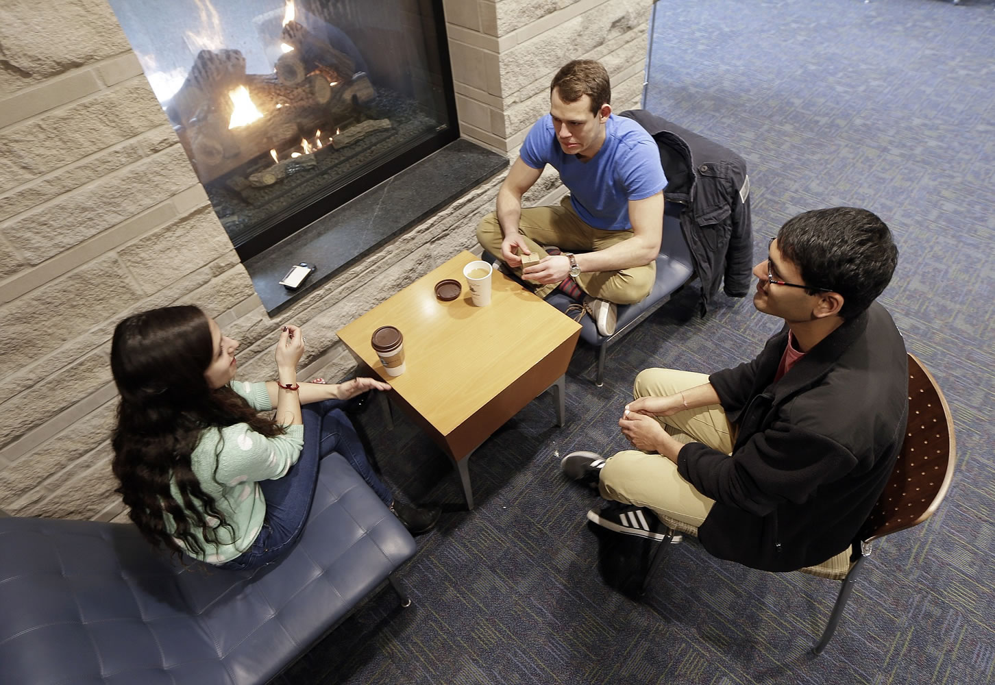 Vivek Shah, right, a sophomore resident advisor at Vanderbilt University, talks with friends Samara Lieberman, left, a senior from Detroit, and Tyler Shull, center, a sophomore from Chapel Hill, N.C., by a fireplace in the great room in the Warren College and Moore College section of the Vanderbilt campus in Nashville, Tenn.  Vanderbilt is one of a small but growing number of U.S.