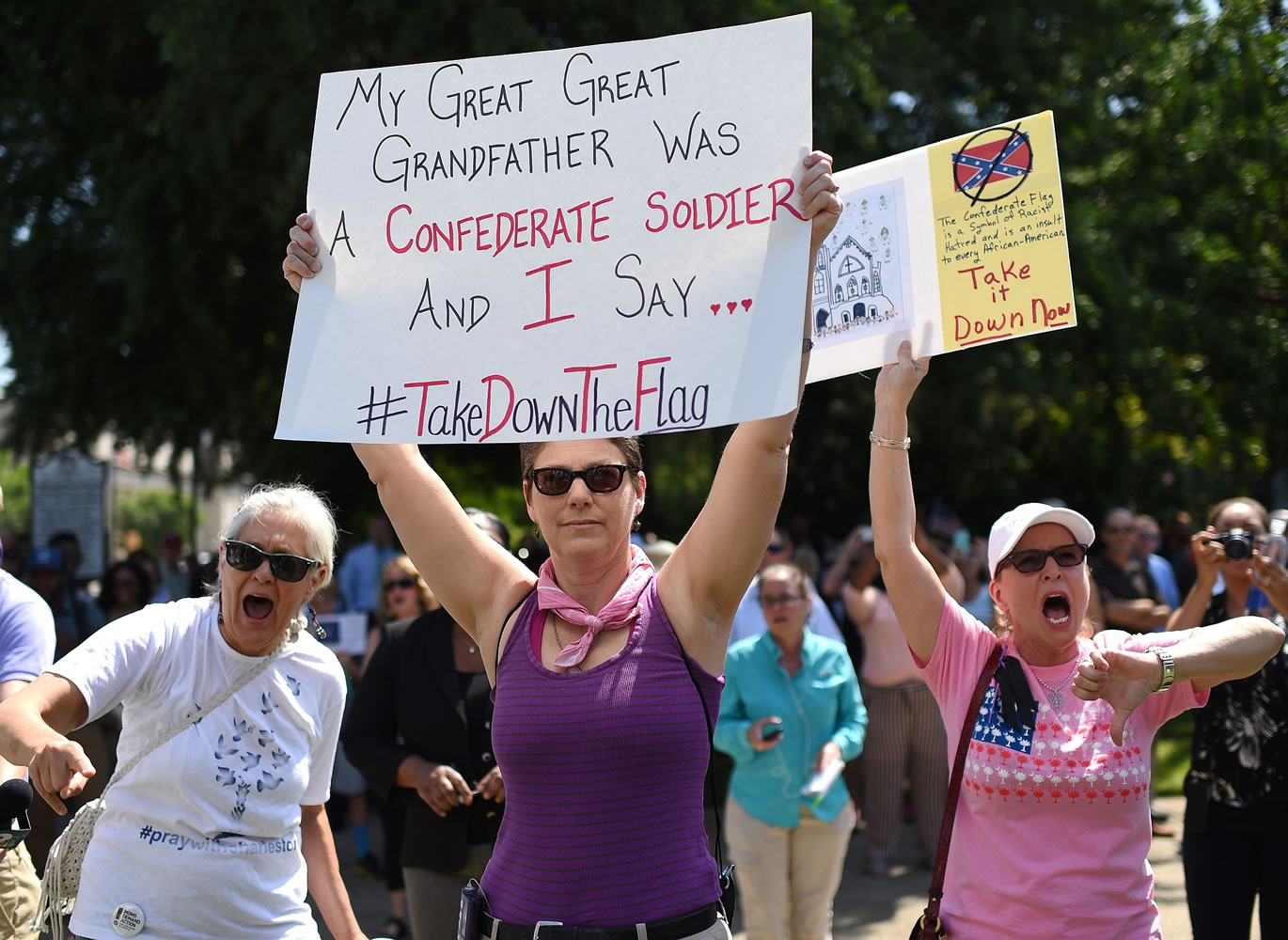 Protesters hold signs as they chant during a rally to take down the Confederate flag at the South Carolina Statehouse on Tuesday in Columbia, S.C.