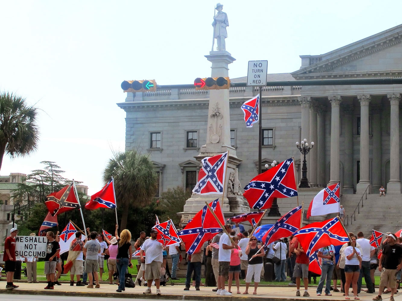 Supporters of keeping the Confederate battle flag flying at a Confederate monument at the South Carolina Statehouse wave flags during a rally Saturday in front of the statehouse in Columbia, S.C.