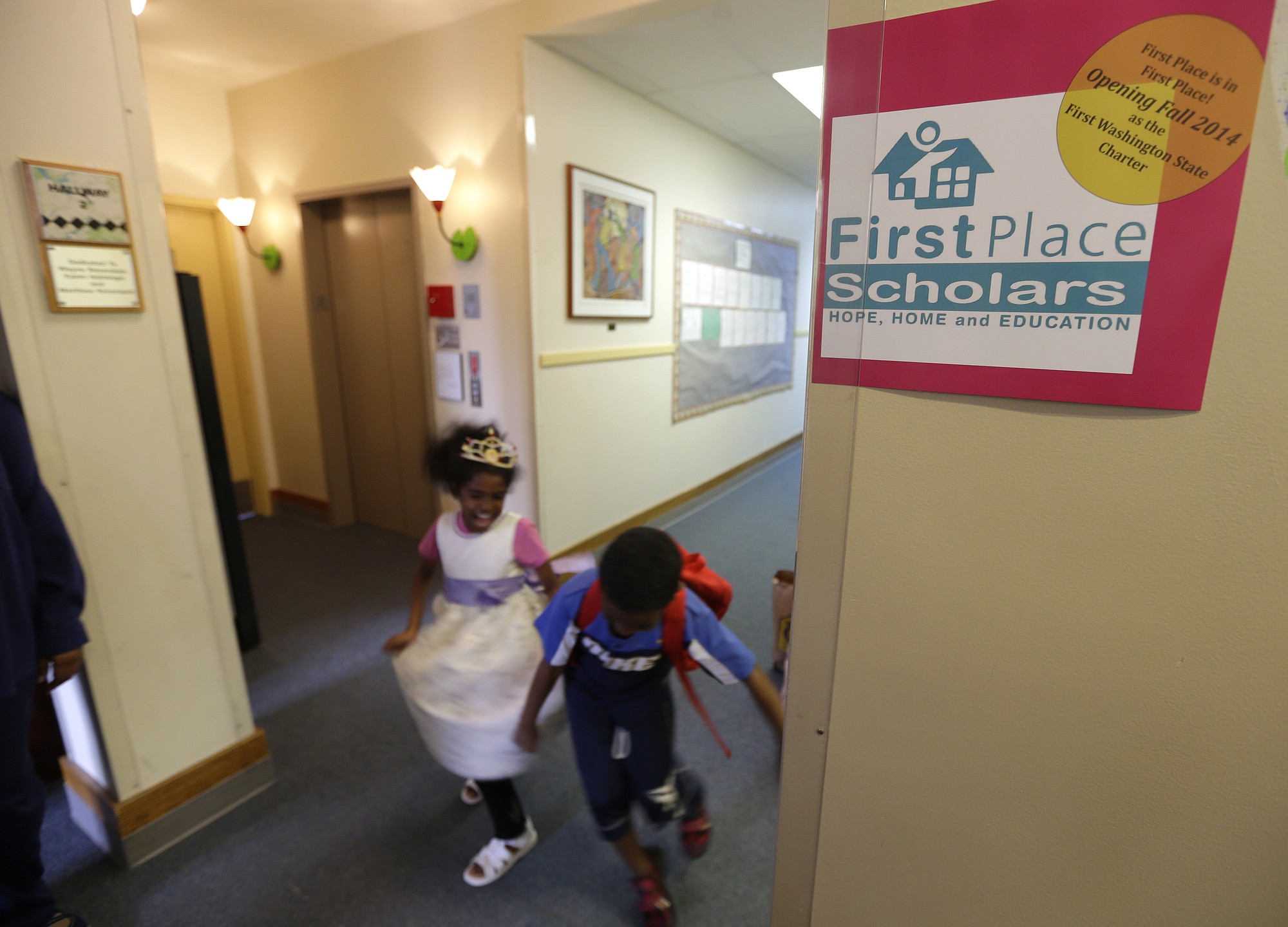 Twins Deborah, left, and Petros Kahssay, 8, walk through a hallway at  First Place Scholars Charter School, Washington's first charter school, in Seattle. It's been a bumpy year for the school, which opened last fall.