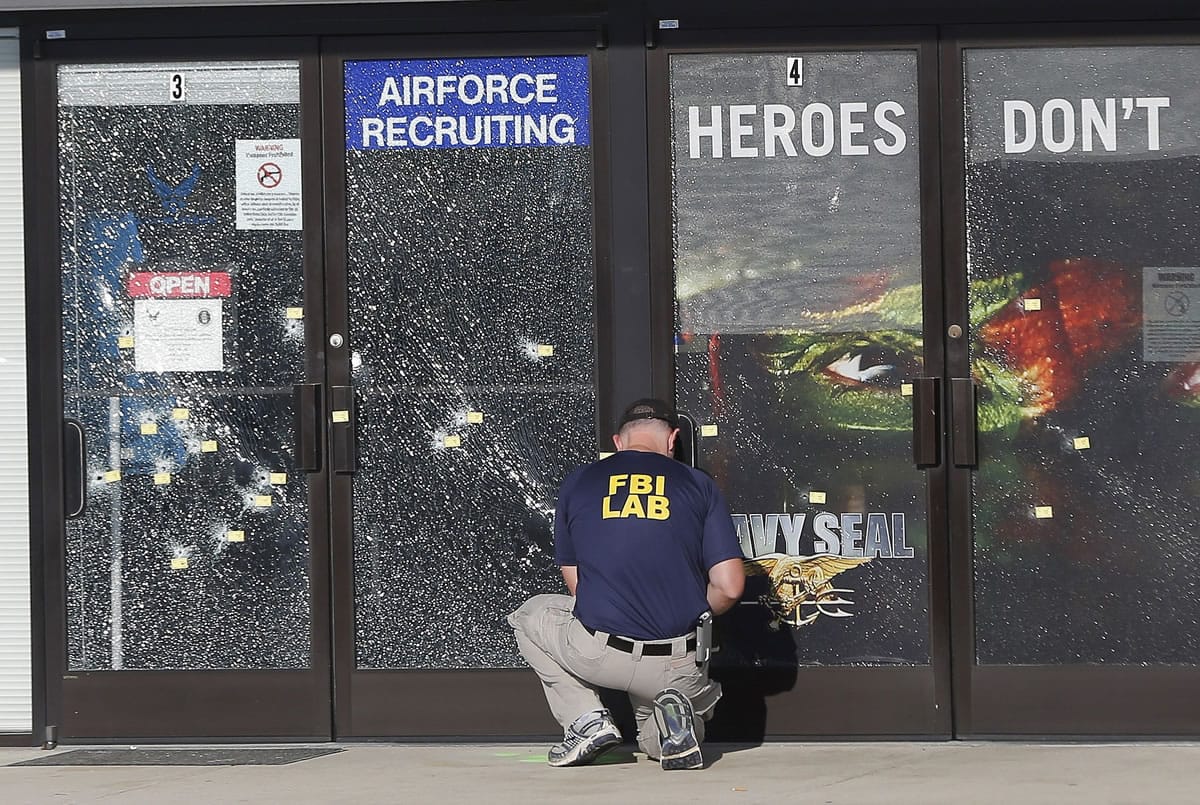 An FBI investigator investigates the scene of a shooting outside a military recruiting center Friday in Chattanooga, Tenn.