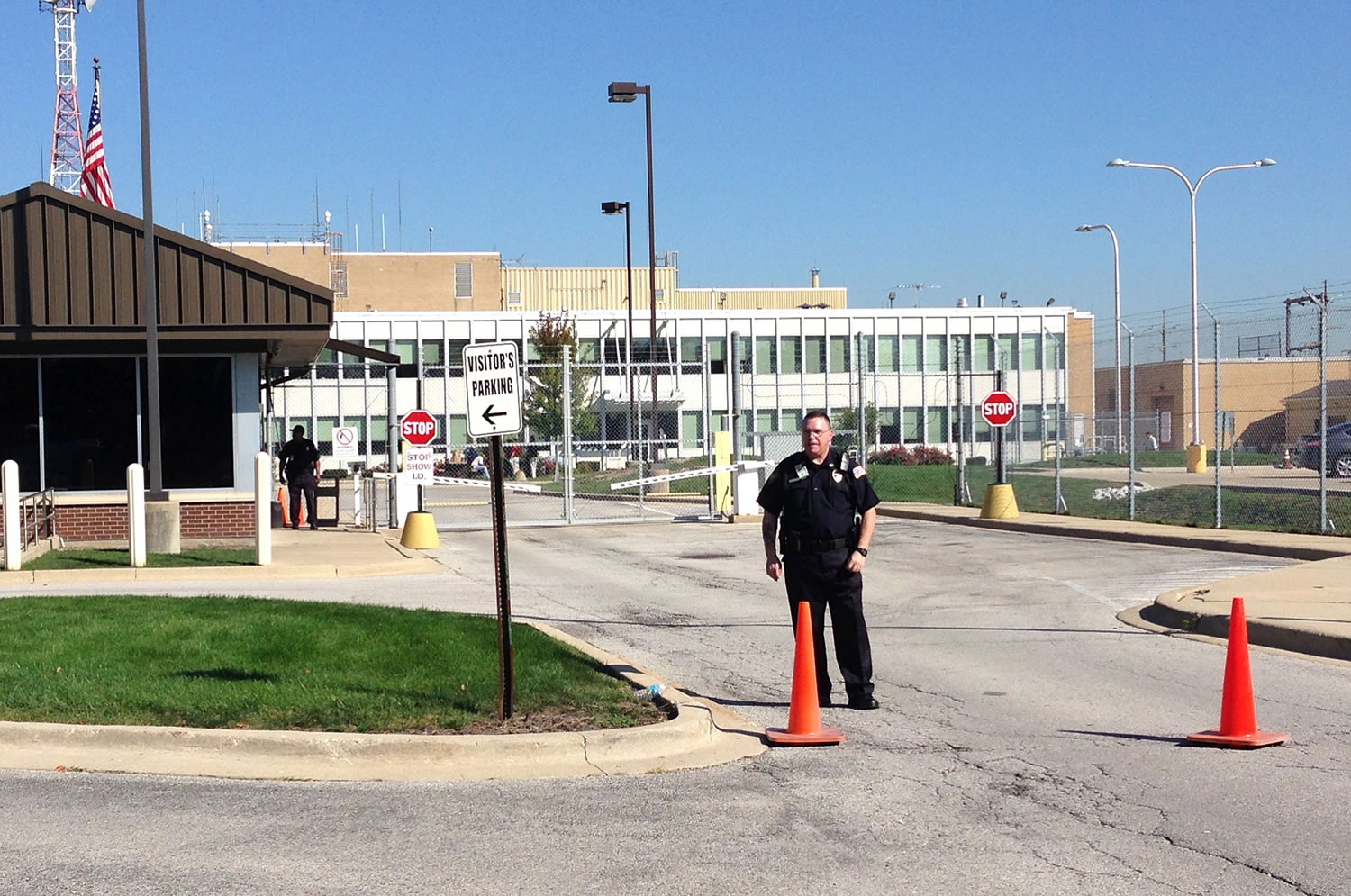 Security stands in front of the air traffic control facility in Aurora, Ill., on Friday. All flights in and out of Chicago's two airports were halted Friday after a fire at the suburban air traffic control facility sent delays and cancellations rippling through the U.S.