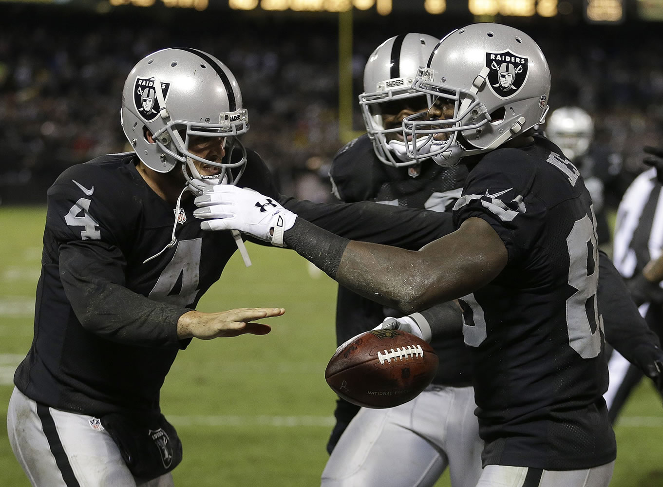 Oakland Raiders quarterback Derek Carr (4) and wide receiver James Jones, right, celebrate after connecting on a 9-yard touchdown pass against the Kansas City Chiefs during the fourth quarter in Oakland, Calif., Thursday, Nov. 20, 2014.