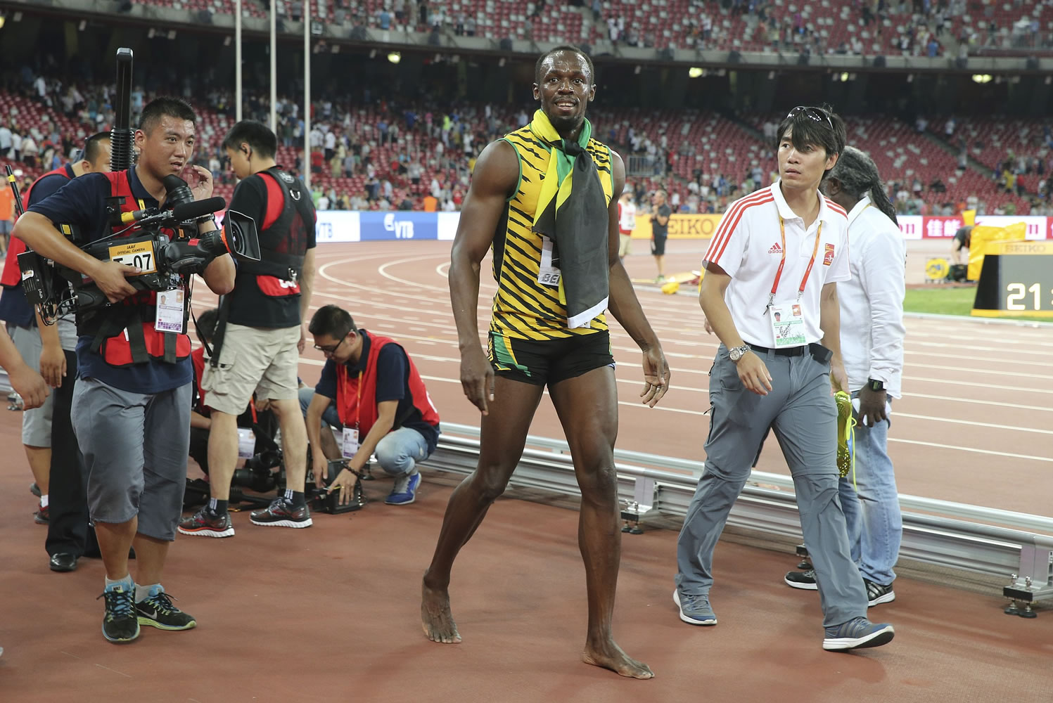 Jamaica's Usain Bolt walks away after being hit by a videographer on a Segway as he celebrated winning the men's 200-meter final at the World Athletics Championships at the Bird's Nest stadium in Beijing, Thursday, Aug. 27, 2015.