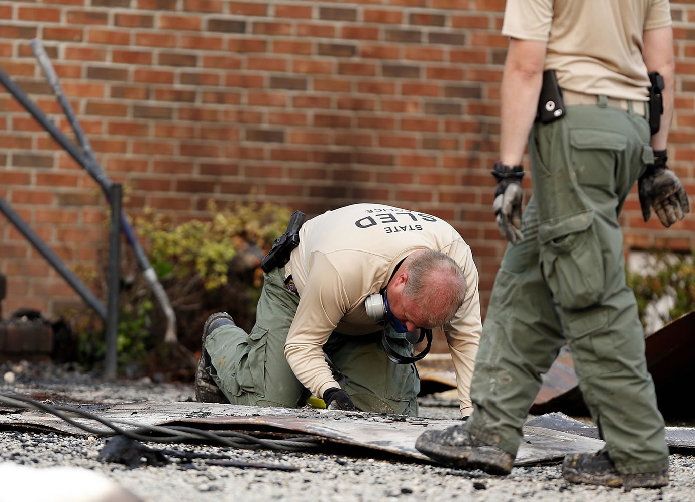 A South Carolina Law Enforcement Division investigator examines the charred remains of a door outside Mount Zion African Methodist Episcopal church Wednesday in Greeleyville, S.C.