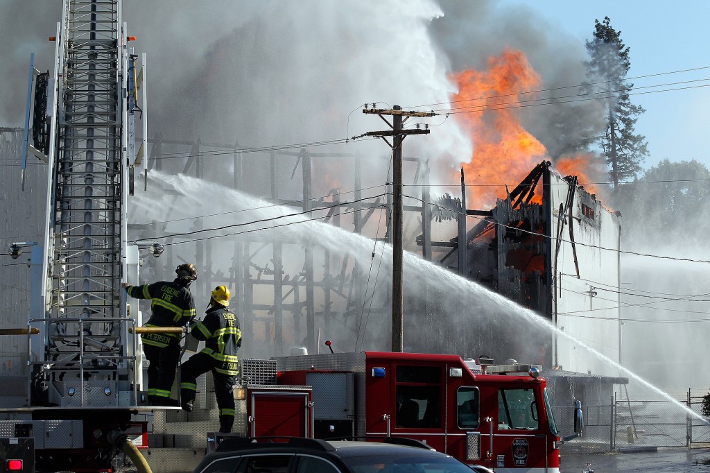 Firefighters work to put out a fire June 29 at the Civic Stadium in Eugene, Ore.