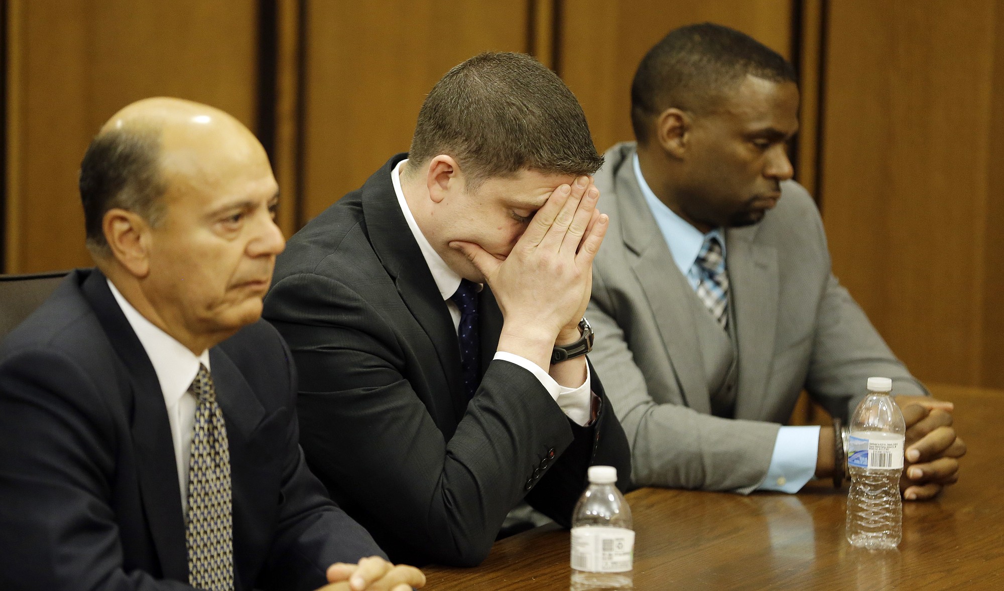 Michael Brelo, center, reacts after the verdict in his trial Saturday in Cleveland. Brelo, a patrolman charged in the shooting deaths of two unarmed suspects during a 137-shot barrage of gunfire was acquitted Saturday in a case that helped prompt the U.S. Department of Justice determine the city police department had a history of using excessive force and violating civil rights.