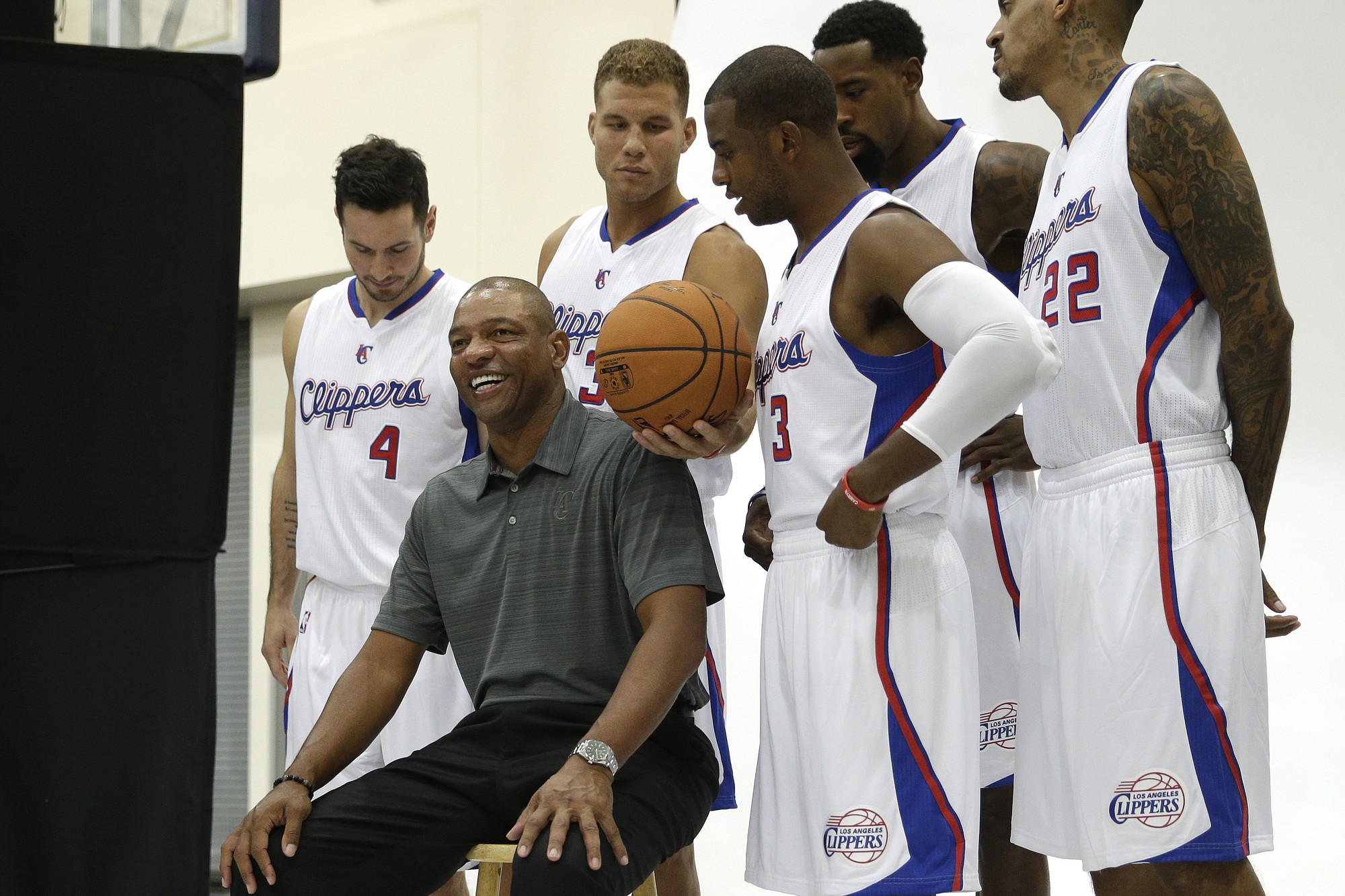 Los Angeles Clippers' Doc Rivers, sitting on a stool, smiles as he poses with players, from left, J.J. Redick, Blake Griffin, Chris Paul, DeAndre Jordan, Matt Barnes during the team's media day Monday, Sept. 29, 2014, in Los Angeles. (AP Photo/Jae C.