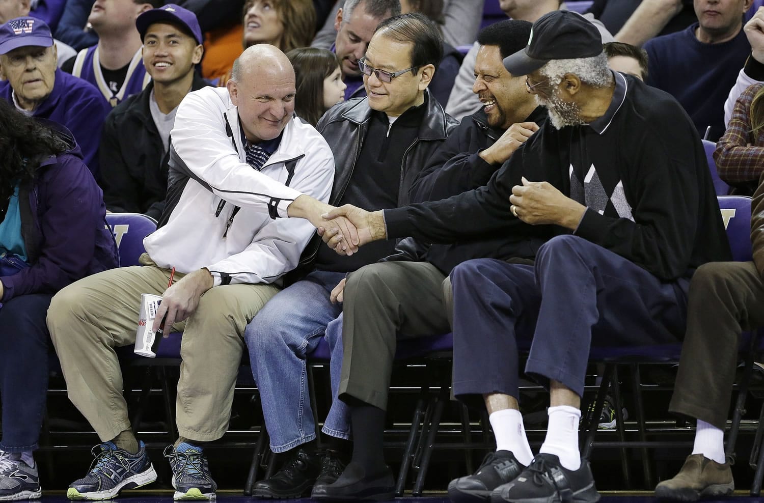 Then-Microsoft CEO Steve Ballmer, left, shakes hands with former NBA players Bill Russell, right, and &quot;Downtown&quot; Freddie Brown as Omar Lee looks on during an NCAA college basketball game between Washington and Oregon State in Seattle in January.