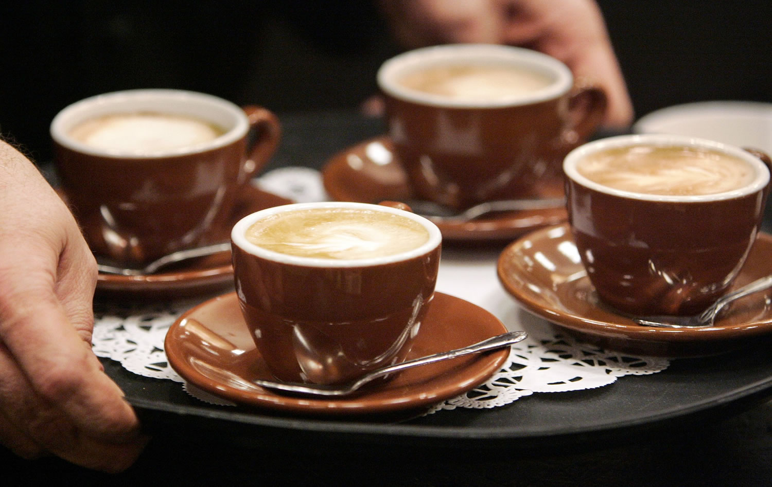 The owner of a coffee shop serves cappuccinos to judges during a barista competition in Cranberry, Pa.