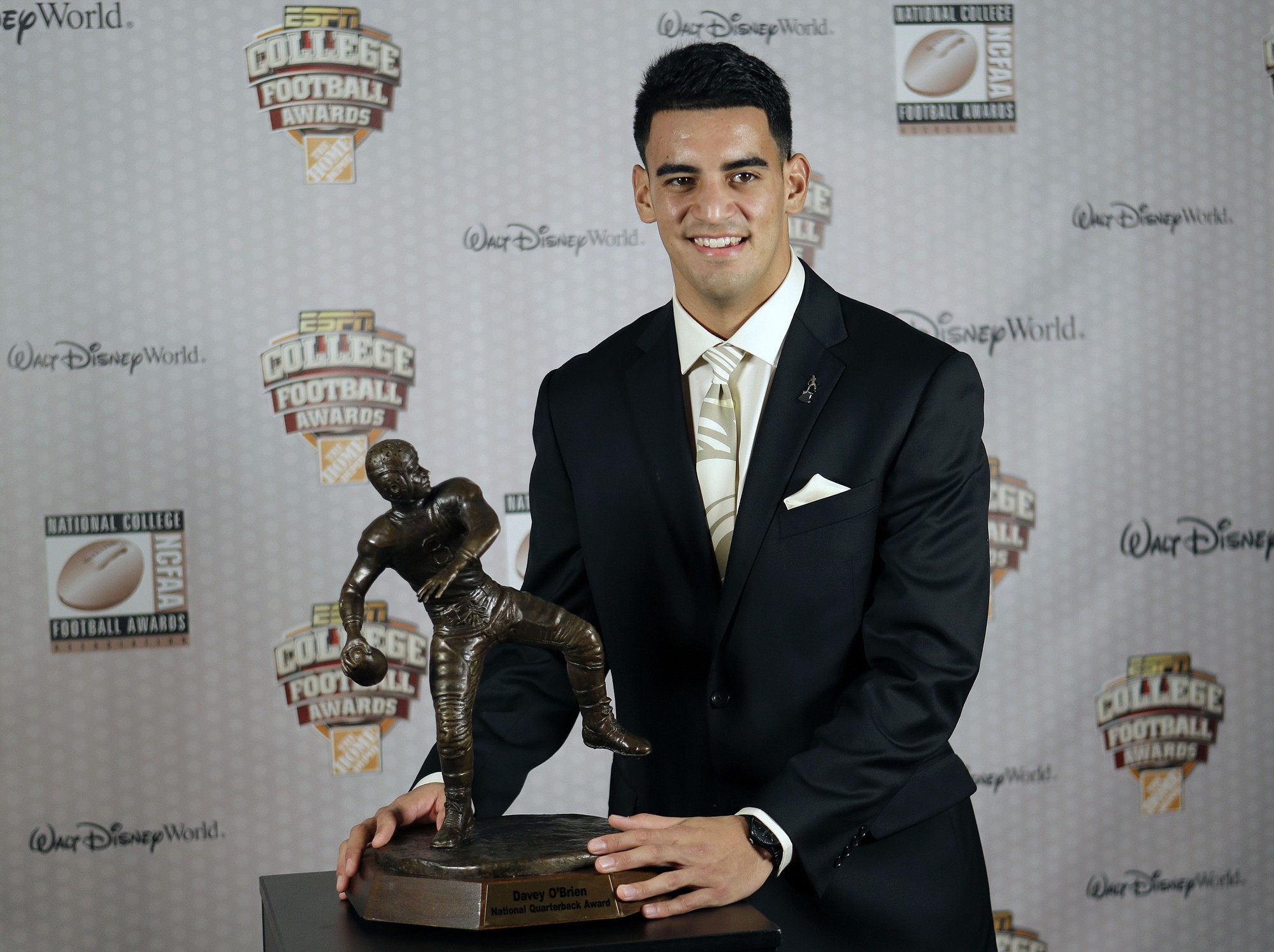 Oregon's Marcus Mariota stands with his trophy after being awarded the Davey O'Brien Award for Nation's Best Quarterback at the College Football Awards, Thursday, Dec. 11, 2014, in Lake Buena Vista, Fla.