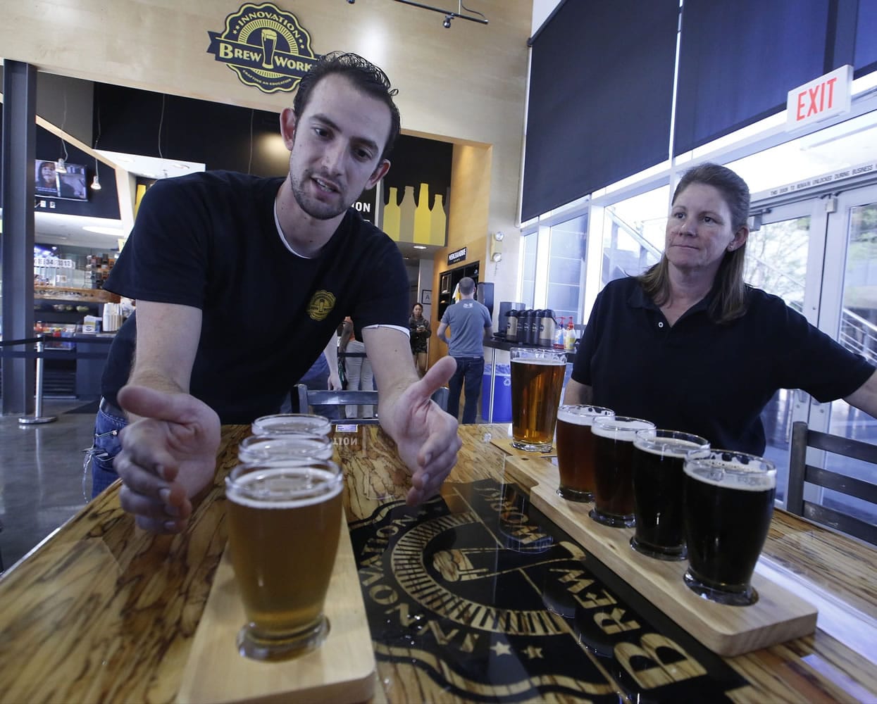 Koby Harris, brewery production manager, left, and Sandra Cain, assistant director of retail operations, present their freshly brewed beers March 19 at Innovation Brew Works in the California State Polytechnic University, Pomona in Pomona, Calif.