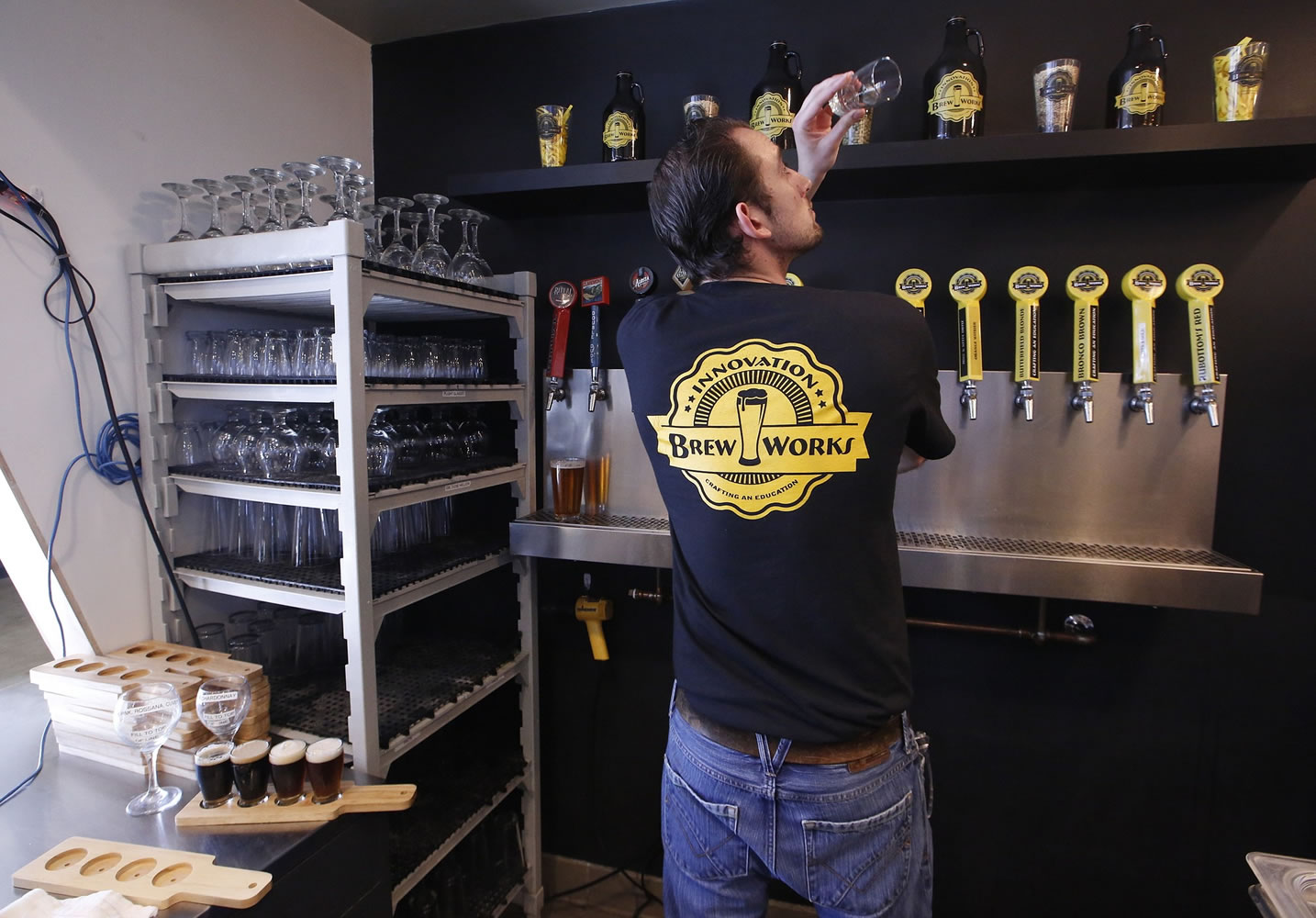In this Thursday, March 19, 2015, photo, Koby Harris, brewery production manager, checks his beer glass before pouring a freshly brewed beer at Innovation Brew Works in the California State Polytechnic University, Pomona in Pomona, Calif. Although the beer made on Pomona's campus is sold at the university's pub, school officials say the effort isn't about providing product for boozy frat boys.
