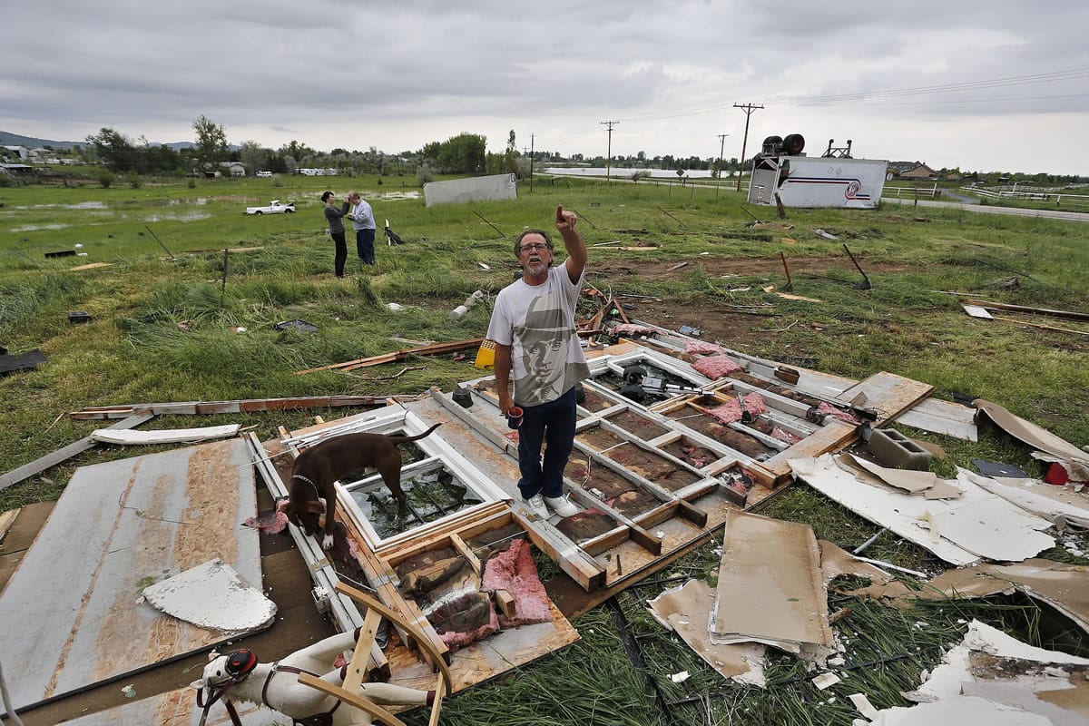 Alvin Allmendinger points to where the roof used to be in the half-gutted home of his brother-in-law, where Allmendinger and family members rode out the previous night's tornado in the basement, southwest of the town of Berthoud, Colo., Friday.
