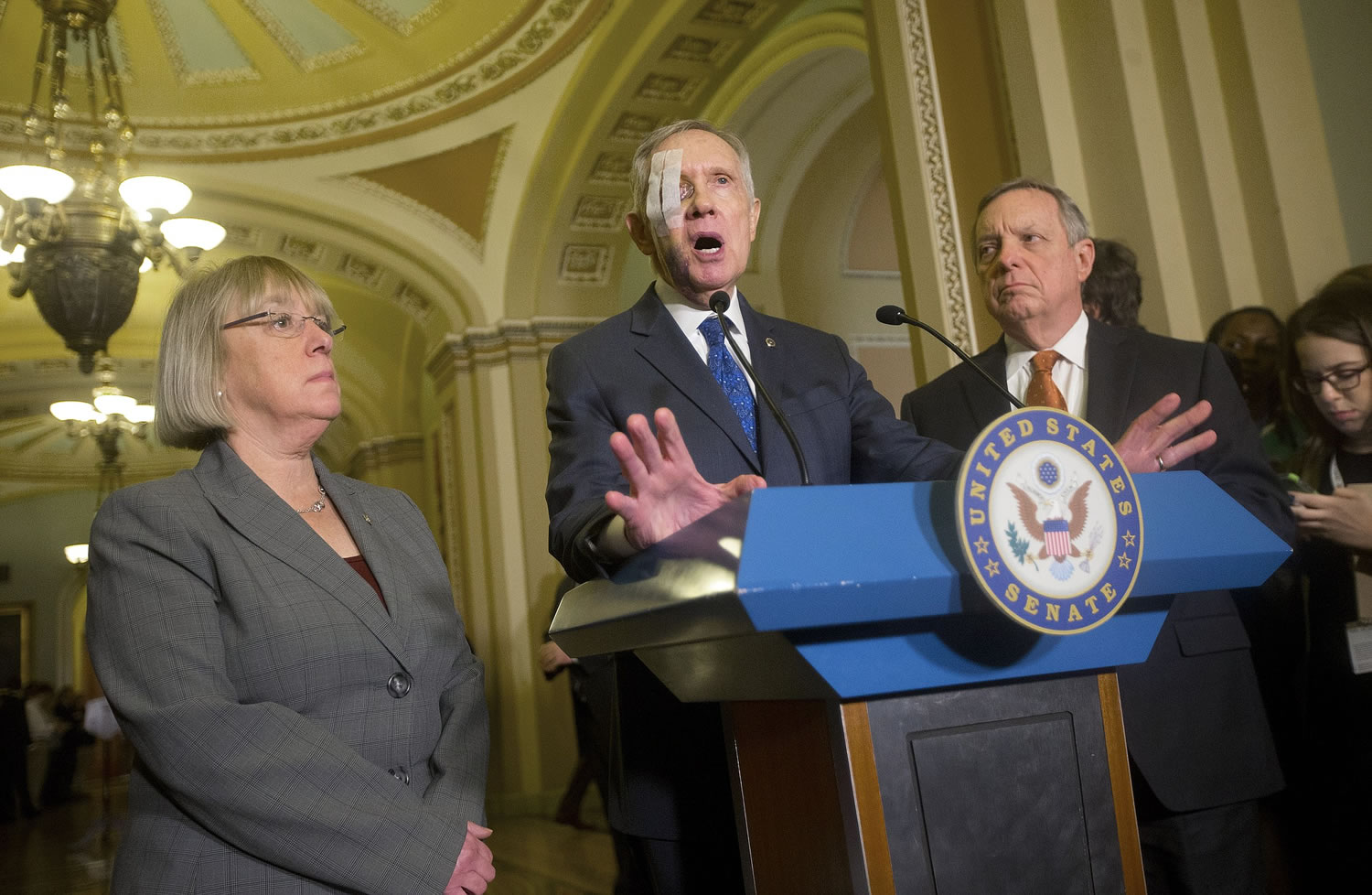 Sen. Patty Murray, D-Wash., left, listens as Democratic Minority Leader Harry Reid, D-Nev., center, answers questions from reporters Tuesday following their weekly policy luncheon, at the Capital in Washington.