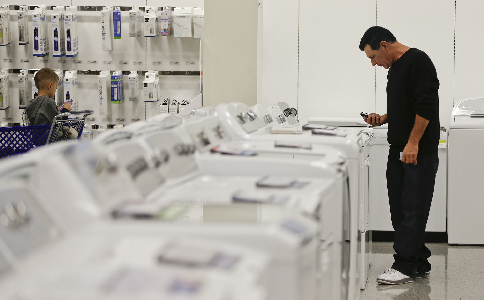 A man examines a row of washers and dryers while shopping at a Sears store in Henderson, Nev.