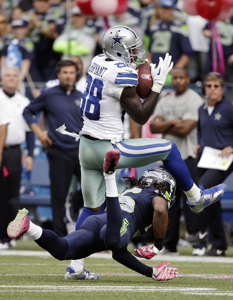 Dallas receiver Dez Bryant (88) had three catches for 52 yards while being covered by Richard Sherman, bottom.