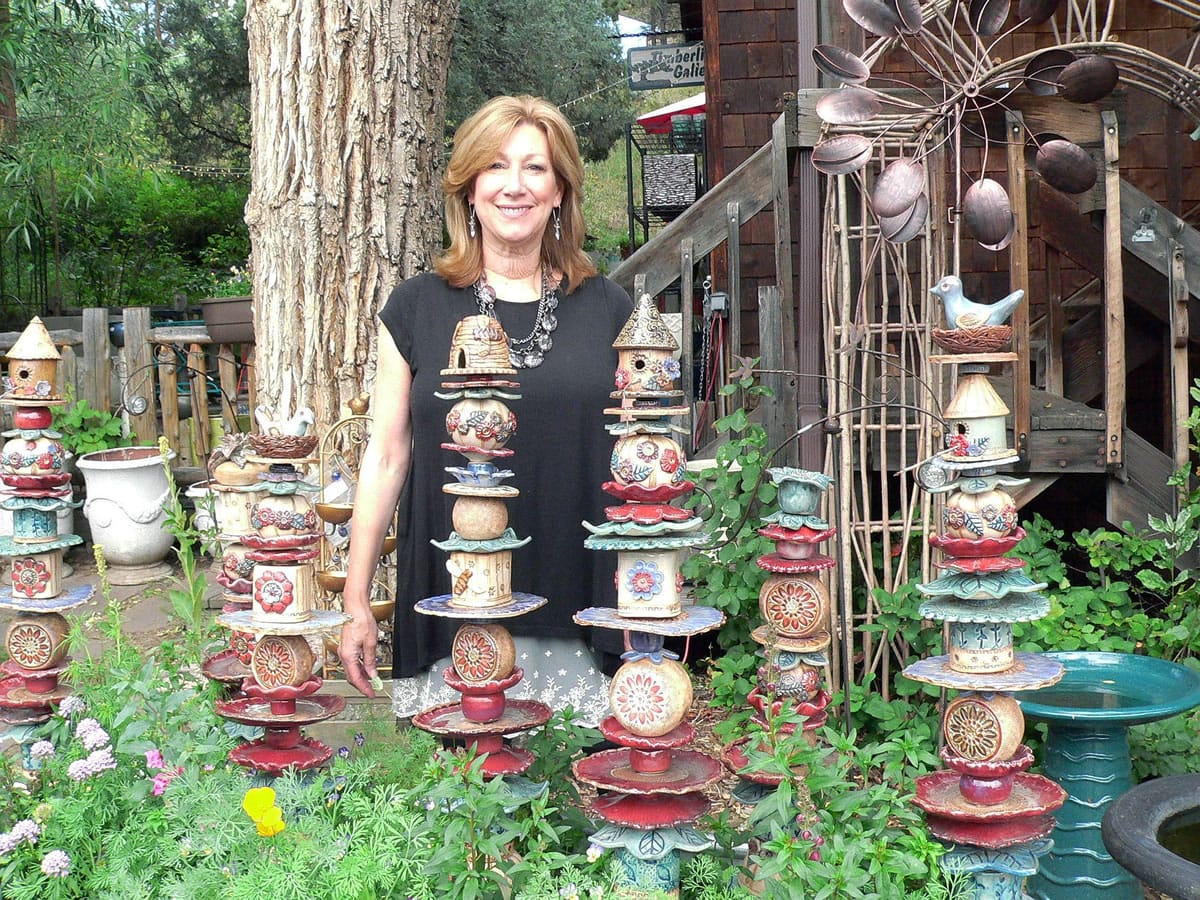 Kathryn Boylston stands among the ceramic garden totems she handcrafts and sells at Sundance by Design, a garden-art shop in Evergreen, Colo.