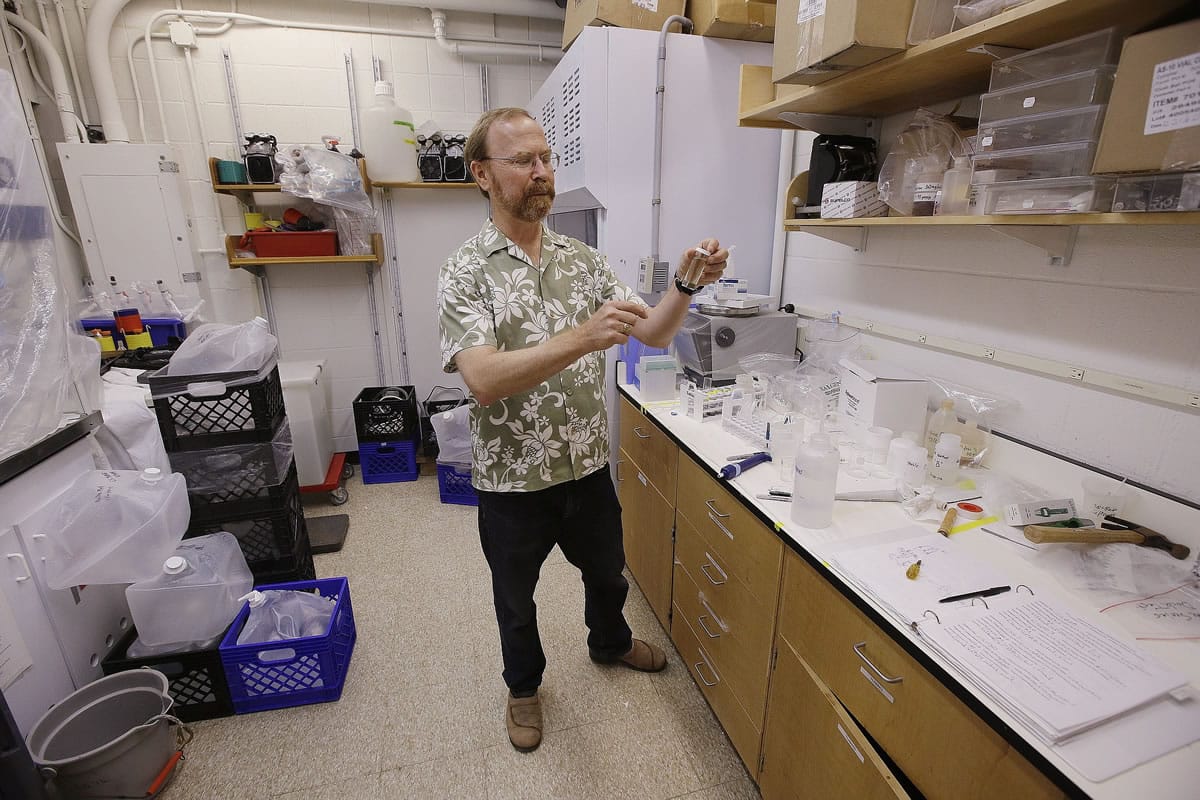 Ken Buesseler, senior scientist of marine chemistry and geochemistry, holds a water sample taken from the Pacific Ocean at his Woods Hole Oceanographic Institution research facility June 30 in Woods Hole, Mass.