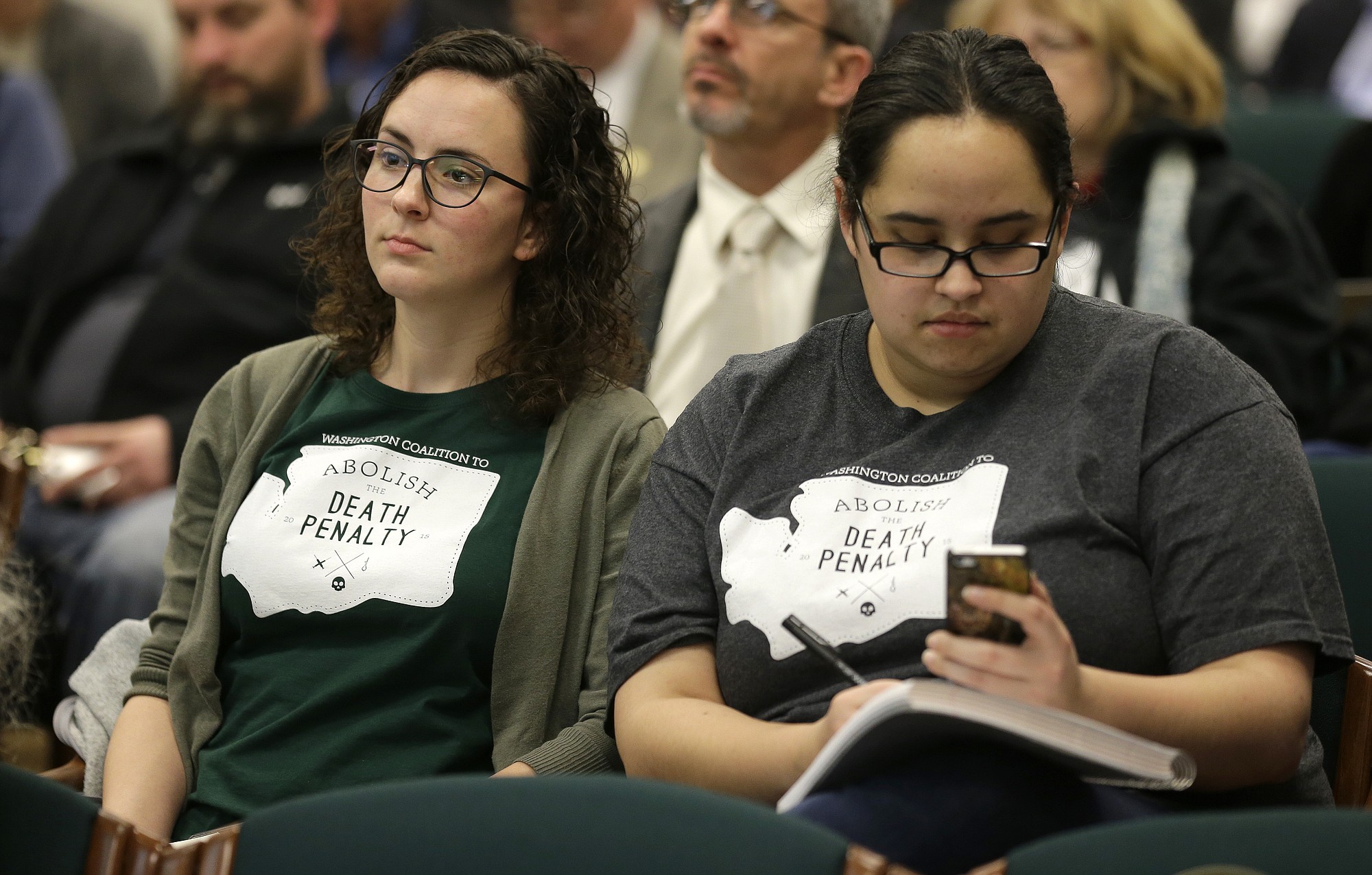 Danielle Fulfs, left, and Xochitl Maykovich , right, both with the Washington Coalition to Abolish the Death Penalty, listen and take notes during a hearing session of House Judiciary Committee, Wednesday, Feb.