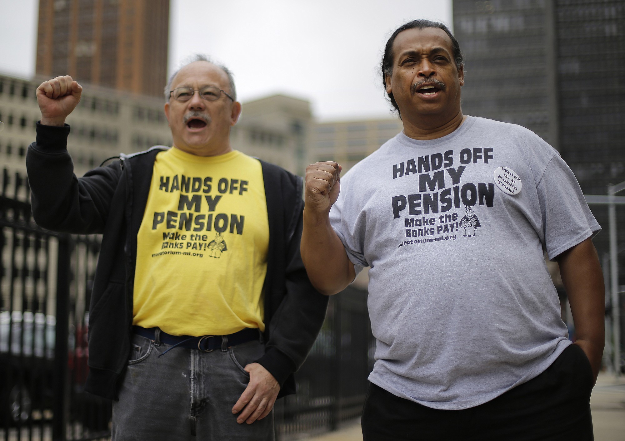 Detroit retirees Mike Shane, left, and William Davis protest near the federal courthouse in Detroit.