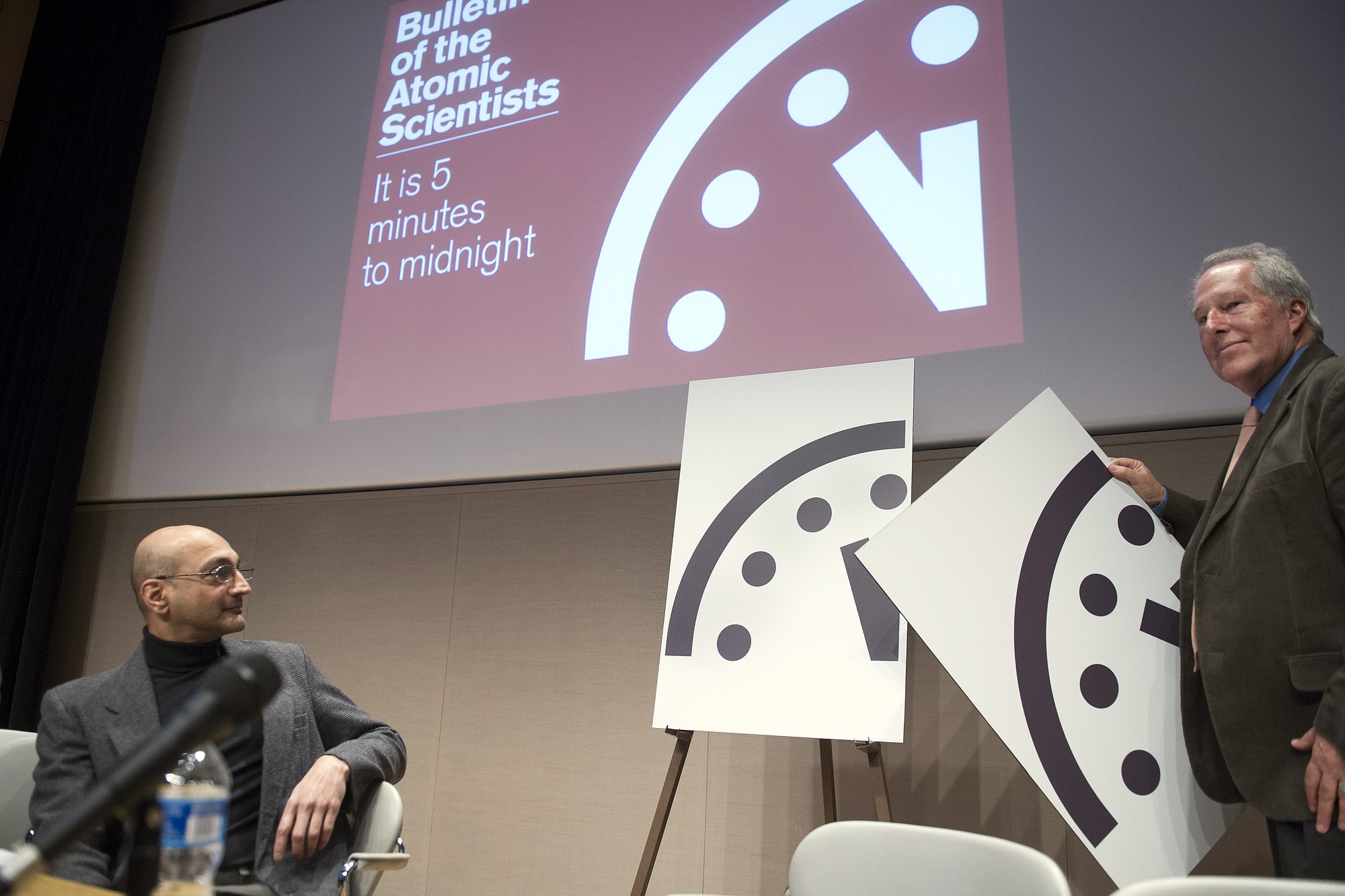 Climate scientist Richard Somerville, member, Science and Security Board, Bulletin of the Atomic Scientists, right, unveils the new Doomsday Clock, accompanied by Sivan Kartha, member, Science and Security Board, Bulletin of the Atomic Scientists and senior scientists at the Stockholm Environmental Institute, right, Thursday, Jan. 22, 2015, in Washington.