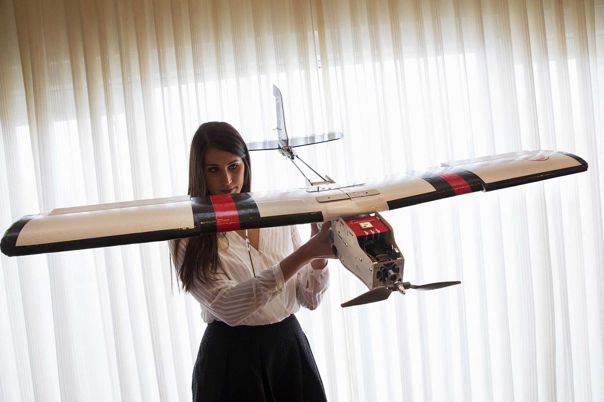 Lia Reich, director of marketing with PrecisionHawk, holds up their agricultural and insurance drone, the PrecisionHawk Lancaster, after a Tuesday event with the Small Unmanned Aerial Vehicles (UAV) Coalition, at the National Press Club in Washington.