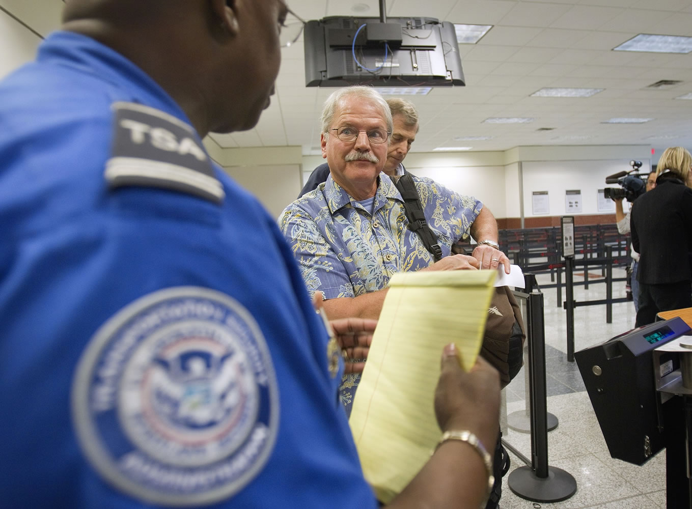 Passenger Don Heim, right, of Alpharetta, Ga., is briefed by Transportation Security Administration trainer Byron Gibson before going through a new expedited security line at Hartsfield-Jackson International Airport in Atlanta.