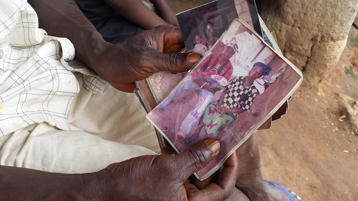 UNICEF
A person holds a family photo of newborn Emile Ouamouno, known as Patient Zero, and his mother and father. Two-year-old Emile, who lived in the forest village of Meliandou, Guinea, was the first known victim of the current Ebola outbreak.