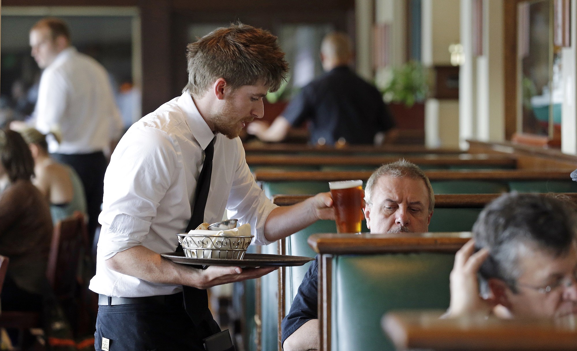 Waiter Spencer Meline serves a customer at Ivar's Acres of Clams restaurant on the Seattle waterfront.