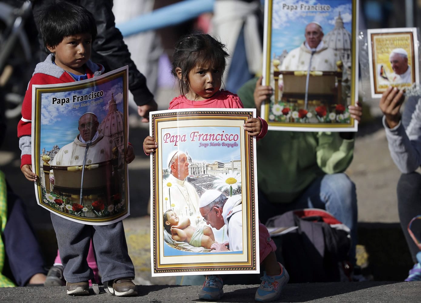Children holding posters wait for the arrival of Pope Francis at the Sanctuary of El Quinche, in El Quinche, Ecuador, on Wednesday.