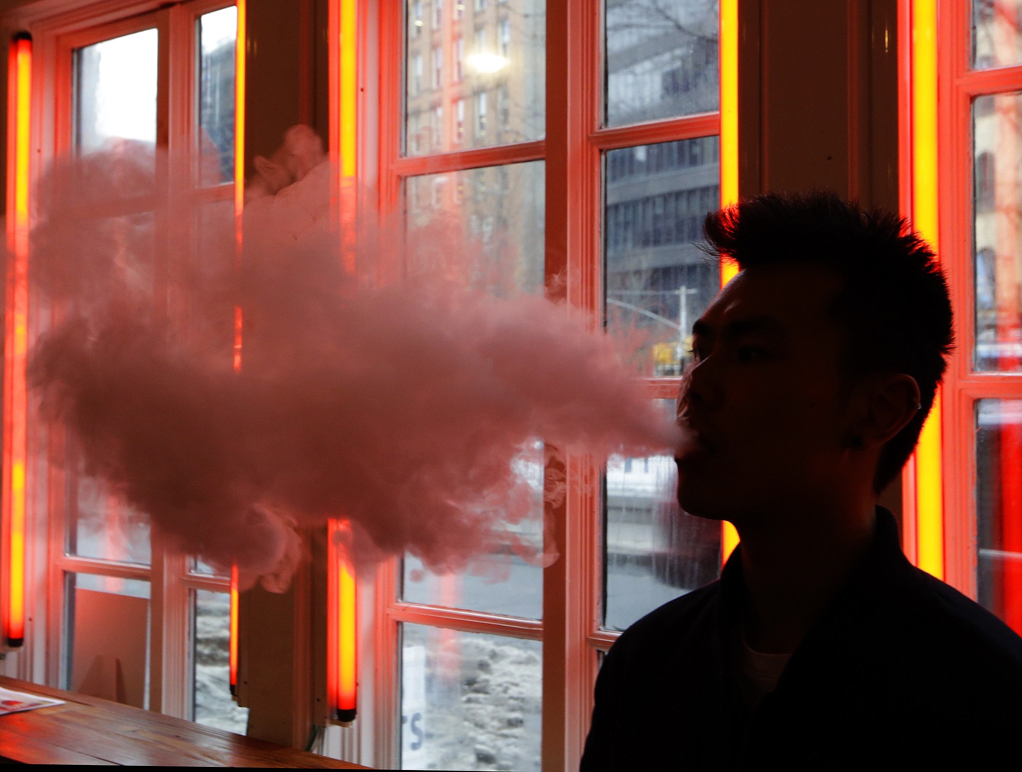 A man exhales vapor from an e-cigarette in New York.