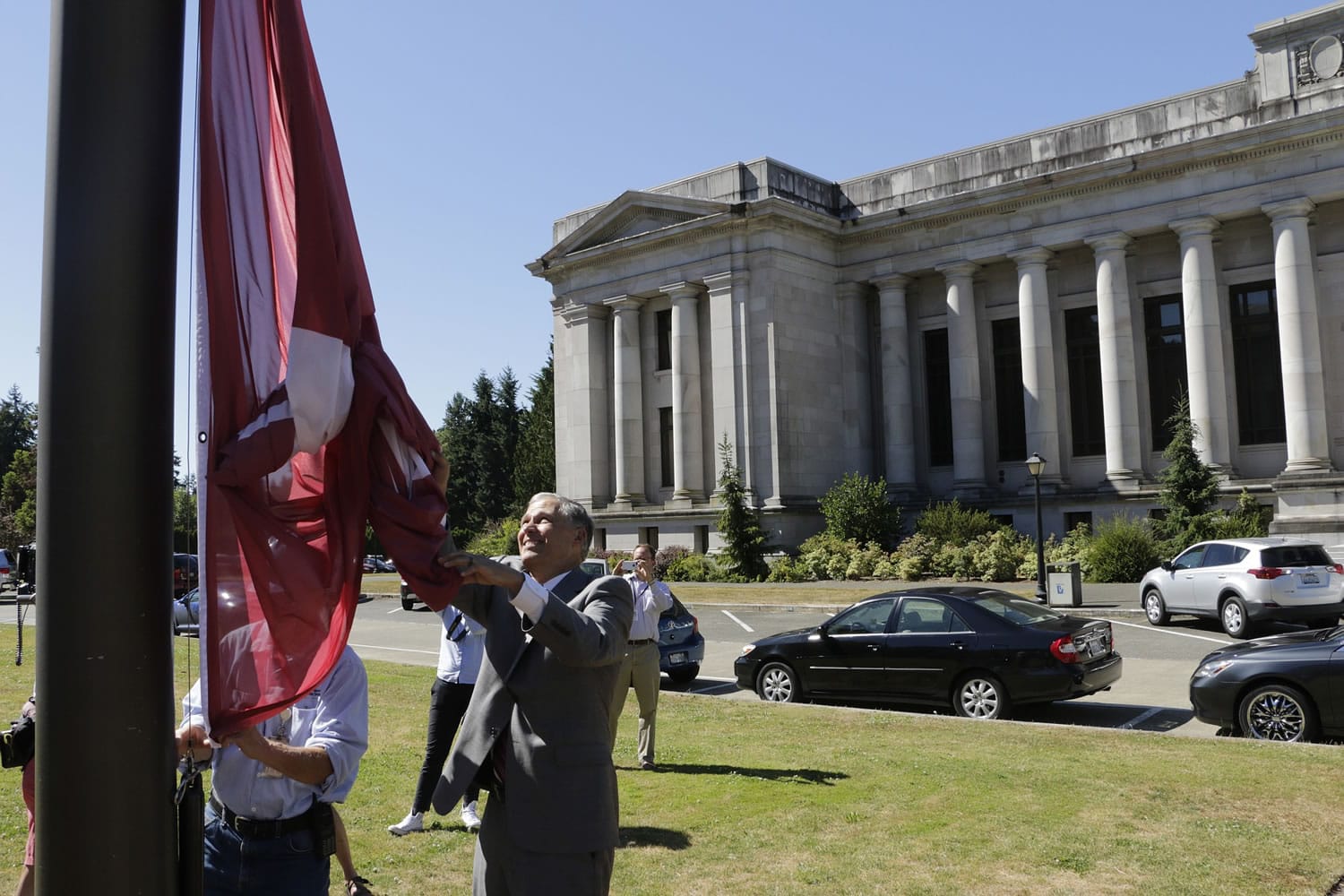 Gov. Jay Inslee raises the flag of Washington State University in honor of its late president, Elson Floyd, on Thursday in Olympia.