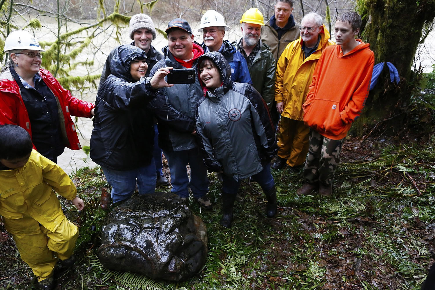 Tribal members and state archaeologists pose for a selfie after a ceremony to celebrate the discovery of a rock that appears to be a carving that depicts a legendary battle in Quileute mythology.