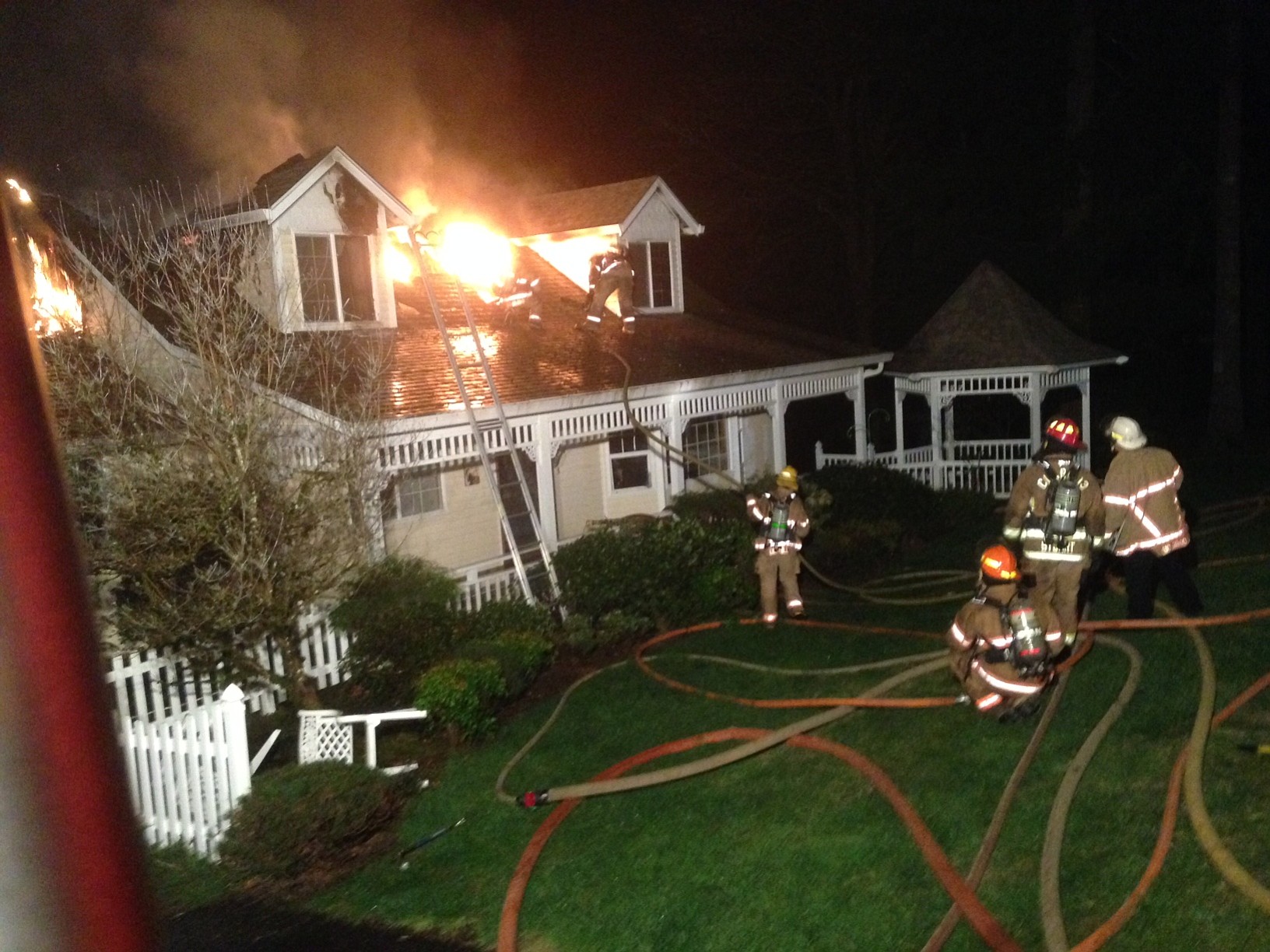 Fire crews work to access a void space in the upper floor of a Yacolt-area home to extinguish the last of the  fire in the upper floor.
