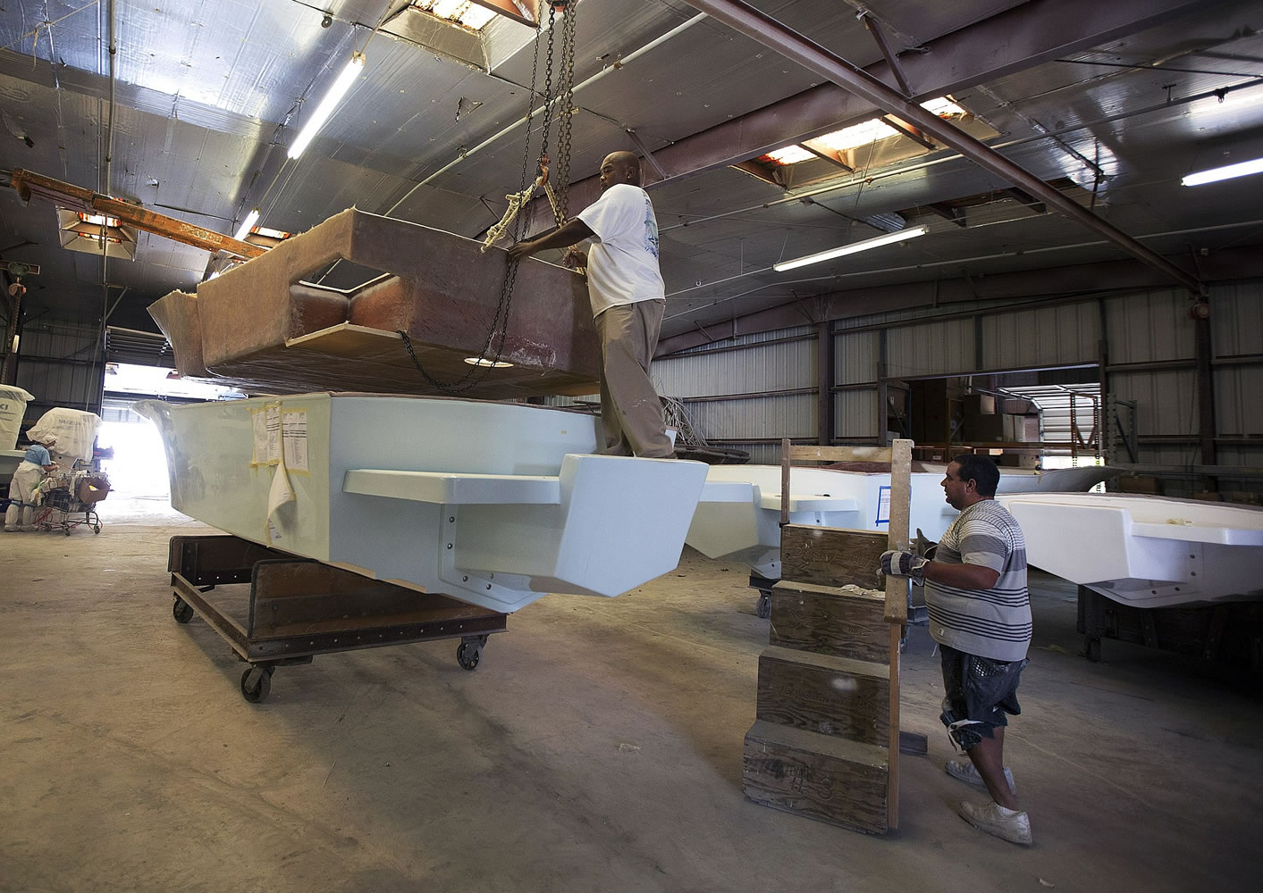 Associated Press files
Workers at the Dusky Marine factory in Dania Beach, Fla., begin to assemble one of the custom boats they built at the family owned business. Each year the company makes 50-100 fishing boats.