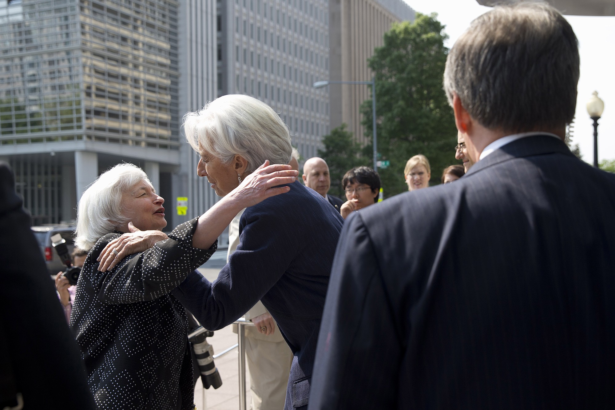 Security members watch as Federal Reserve Chair Janet Yellen, left, and International Monetary Fund Managing Director Christine Lagarde hug goodbye outside the IMF in Washington, on Wednesday after Yellen spoke at the Institute for New Economic Thinking Conference on Finance and Society.