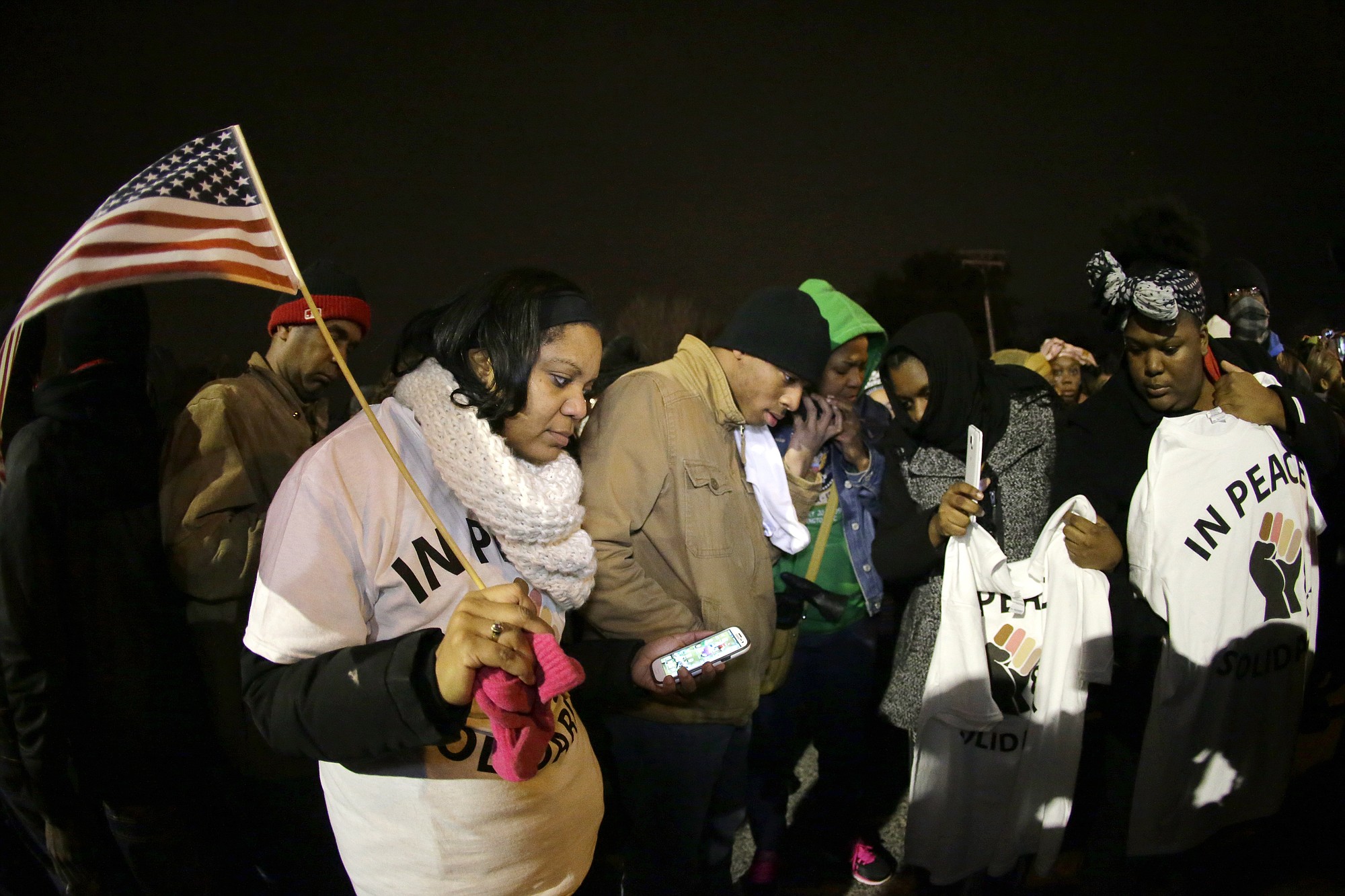 Protesters listen Monday to the announcement of the grand jury decision in Ferguson, Mo.