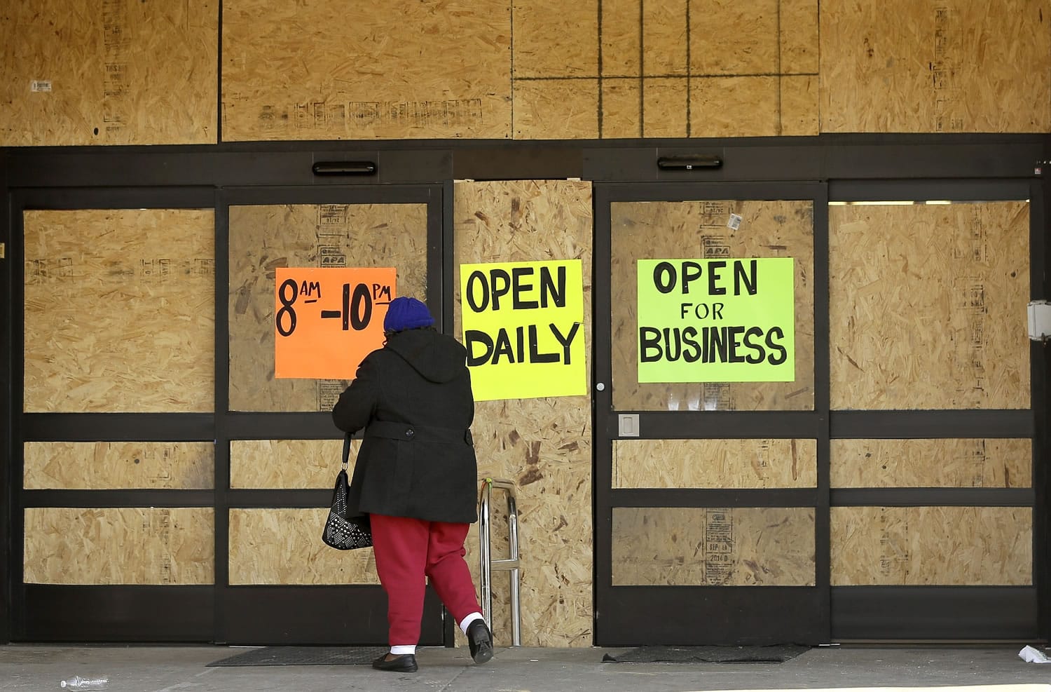 A woman walks into an open but boarded up business Thursday, Nov. 20, 2014, in Ferguson, Mo. Ferguson and the St. Louis region are on edge in anticipation of the announcement by a grand jury whether to criminally charge Officer Darren Wilson in the killing of 18-year-old Michael Brown.
